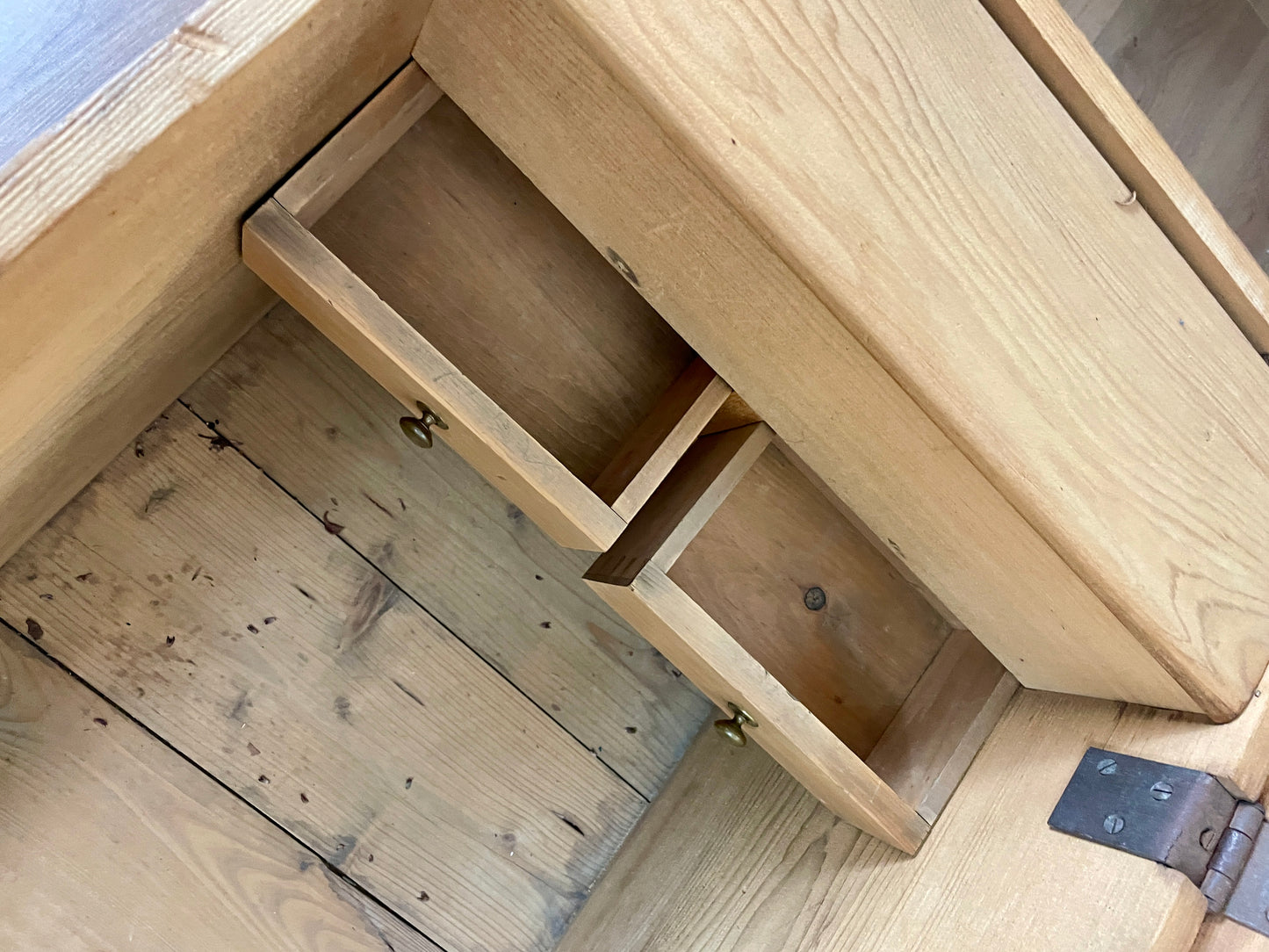 Wooden furniture with open drawers on a wooden floor.