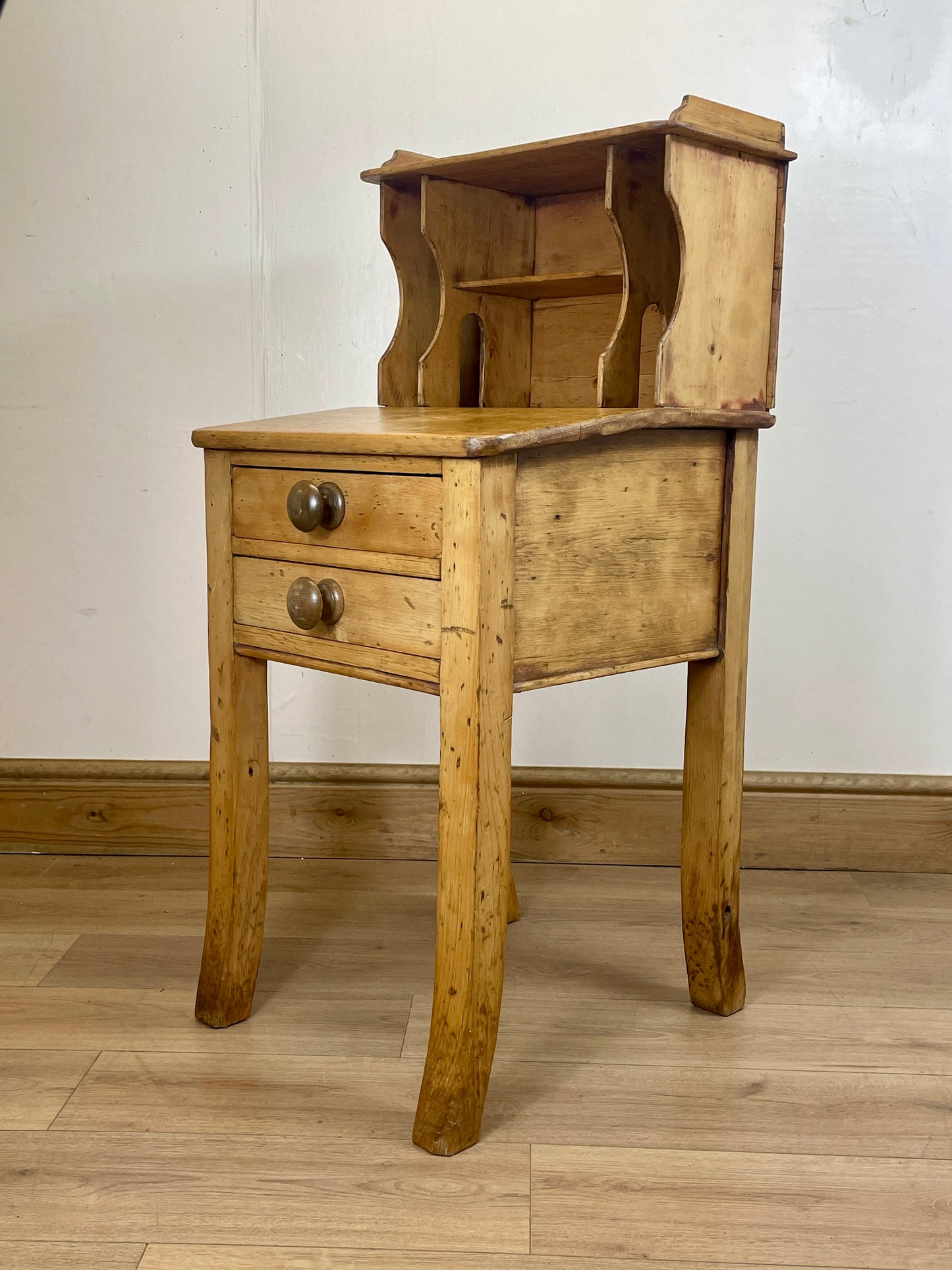 Vintage wooden side table with two drawers on a wooden floor.