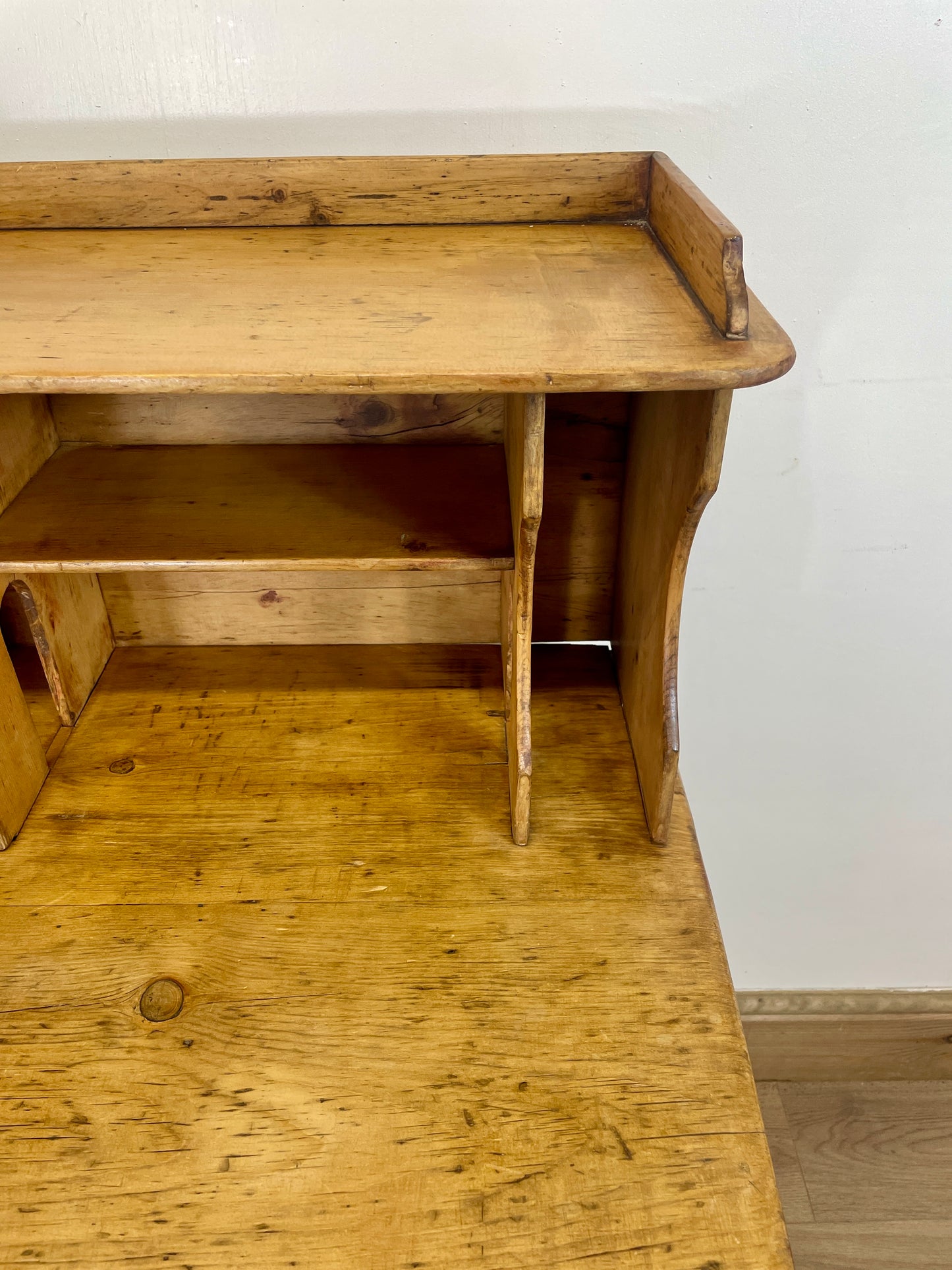 Wooden desk with a shelf against a white wall