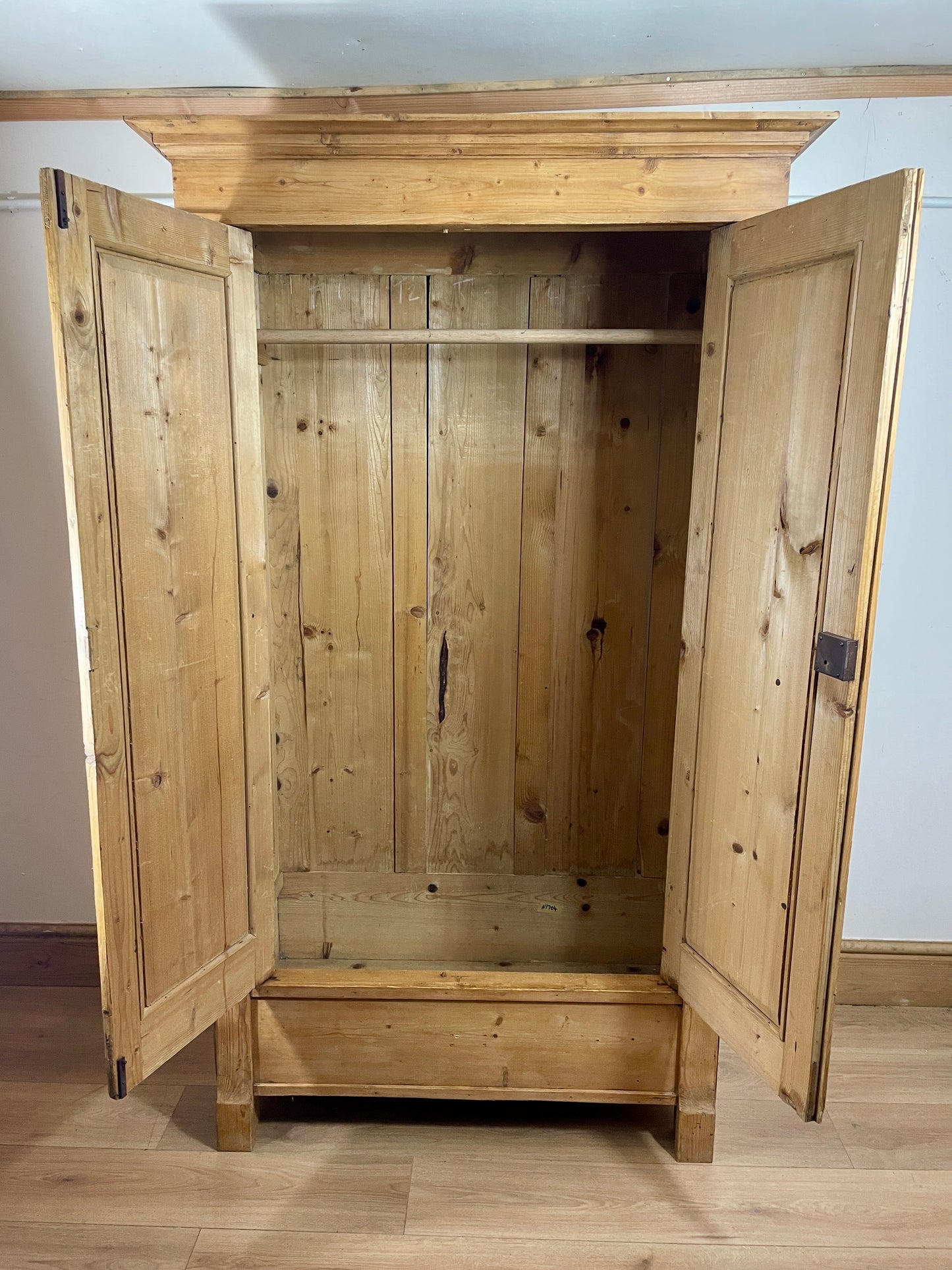 Wooden wardrobe with open doors on a wooden floor.