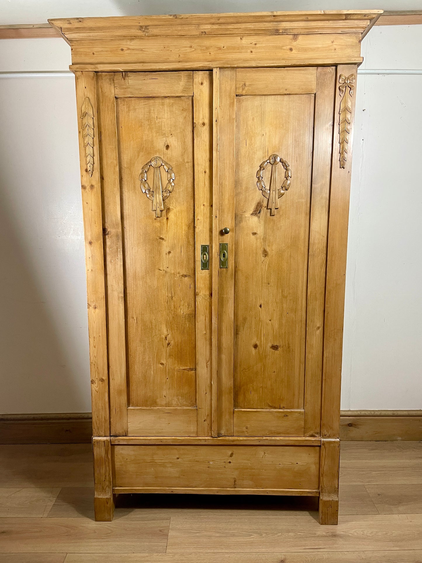 Wooden wardrobe with decorative elements on a white wall