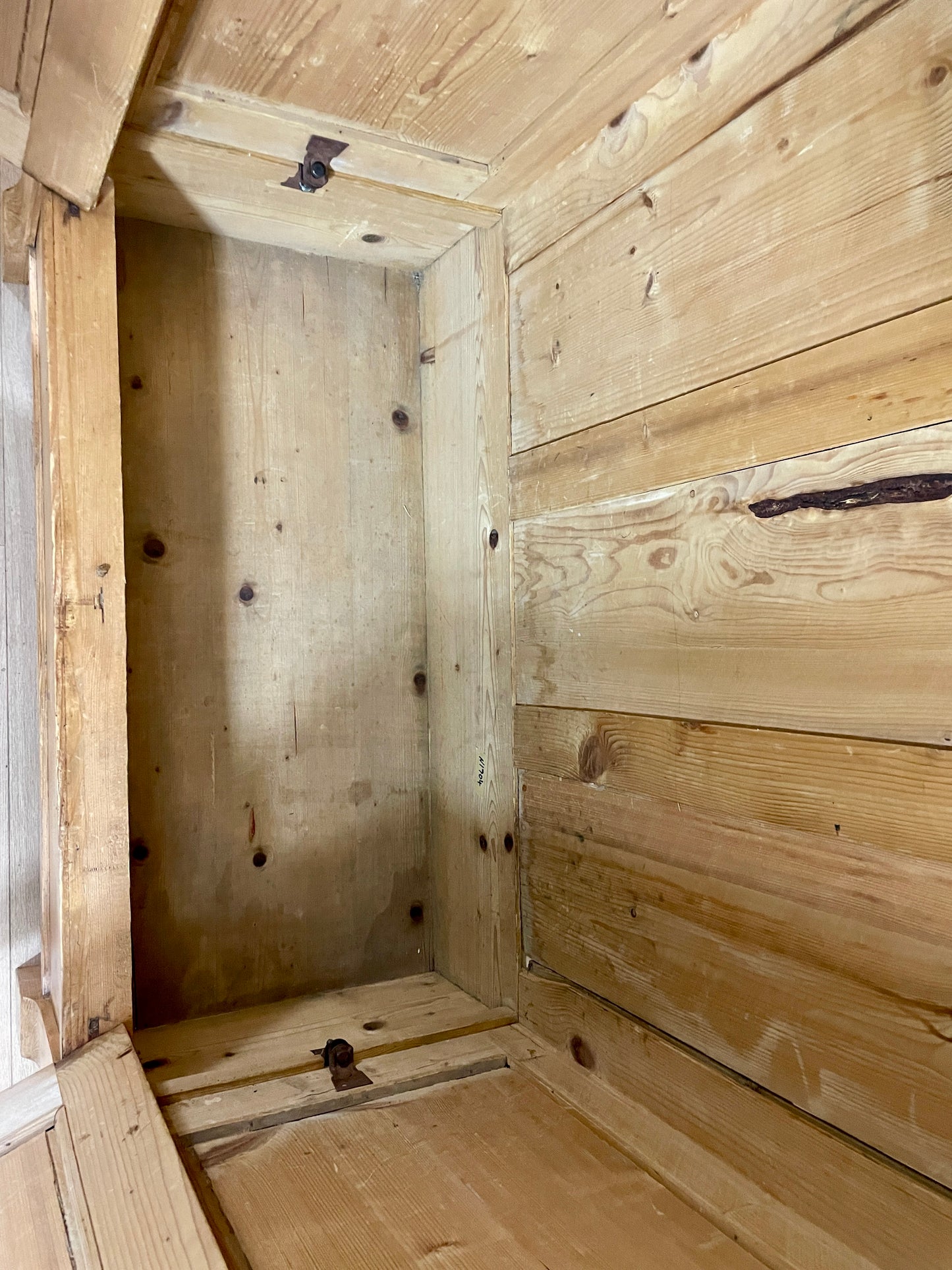 Wooden interior of a structure with visible nails and rough texture