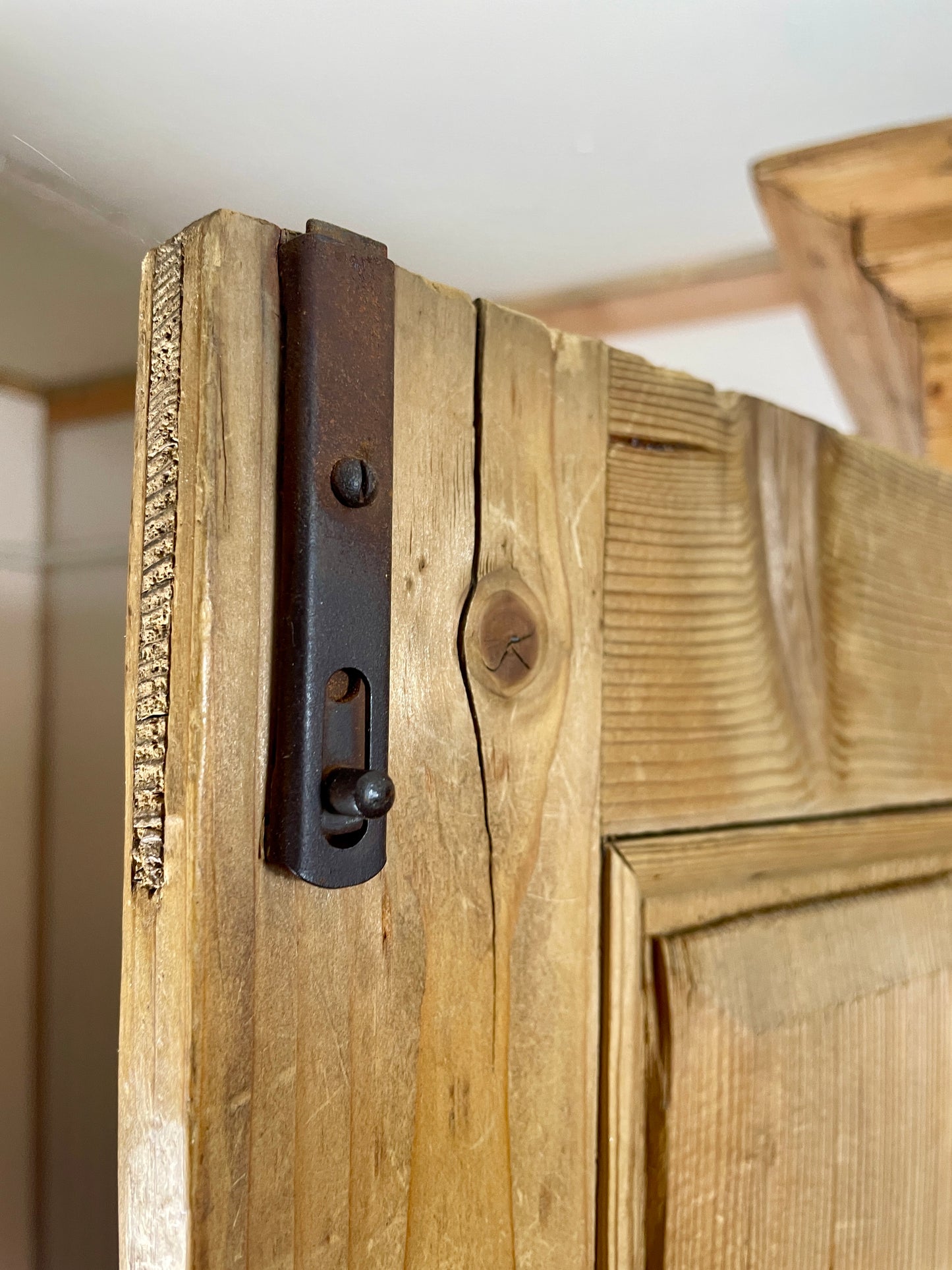 Close-up of a wooden door with a metal hinge