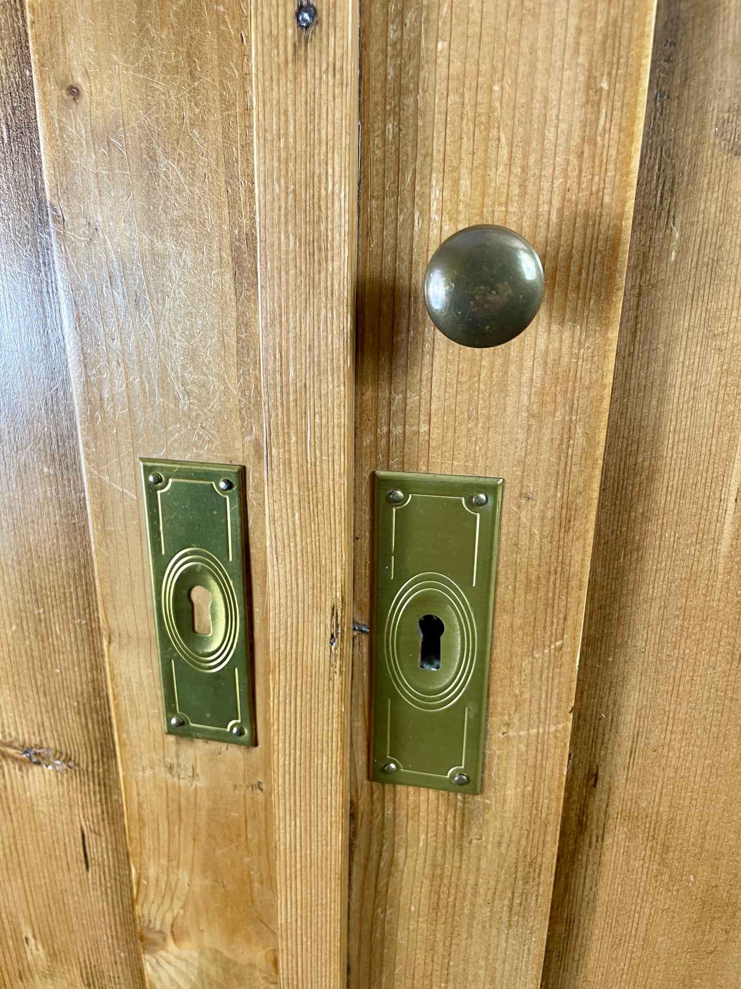Wooden door with brass doorknob and keyhole plates