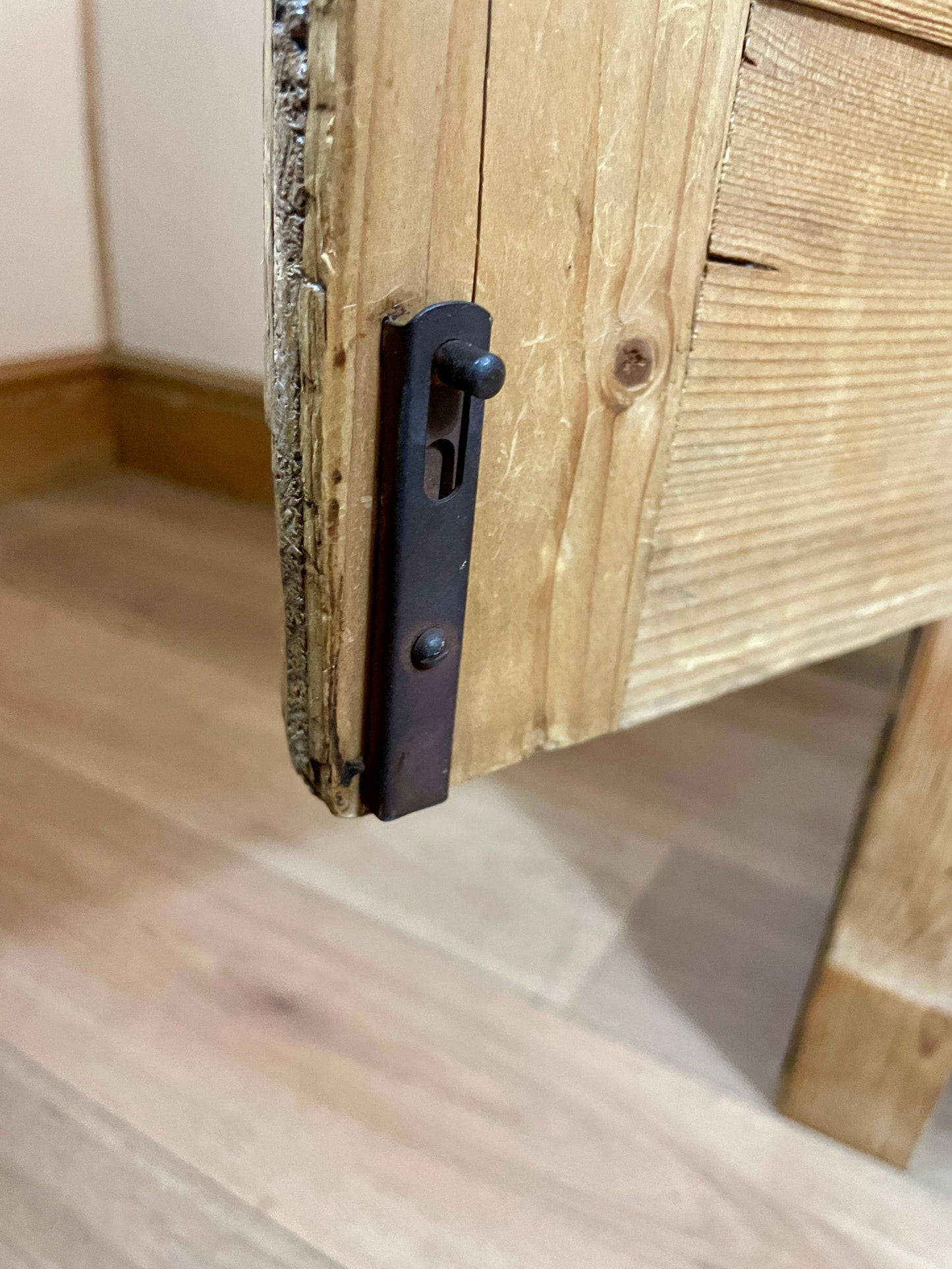 Close-up of a wooden cabinet with a metal handle