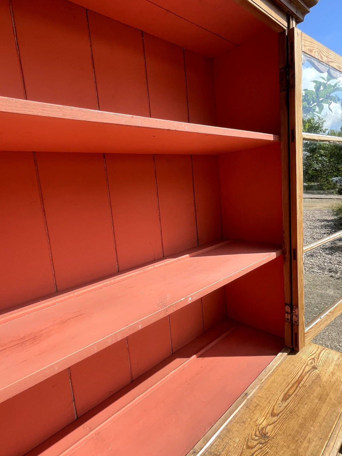 Red wooden shelves outdoors with a clear sky background