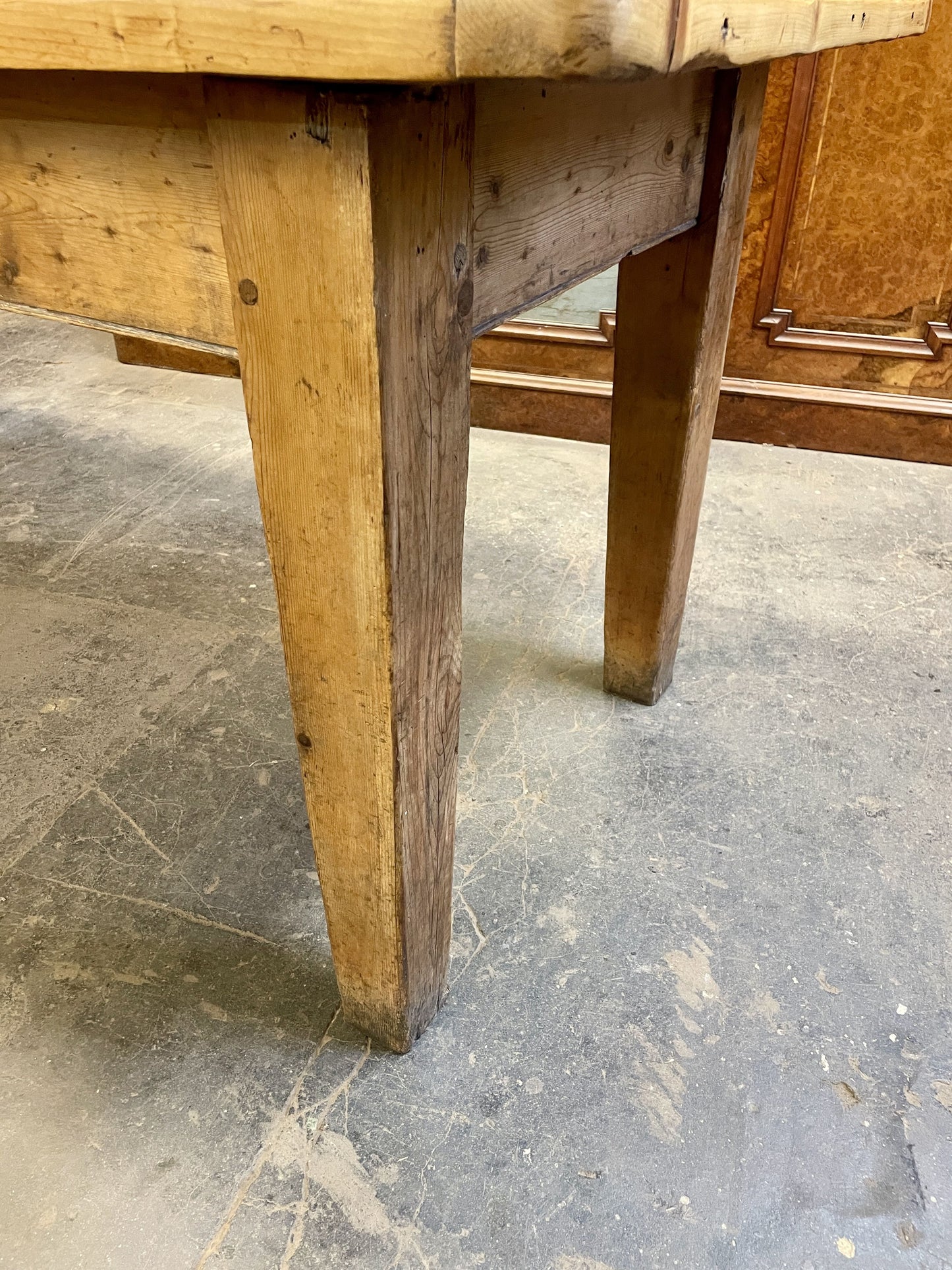 Close-up of a wooden table leg on a stone floor