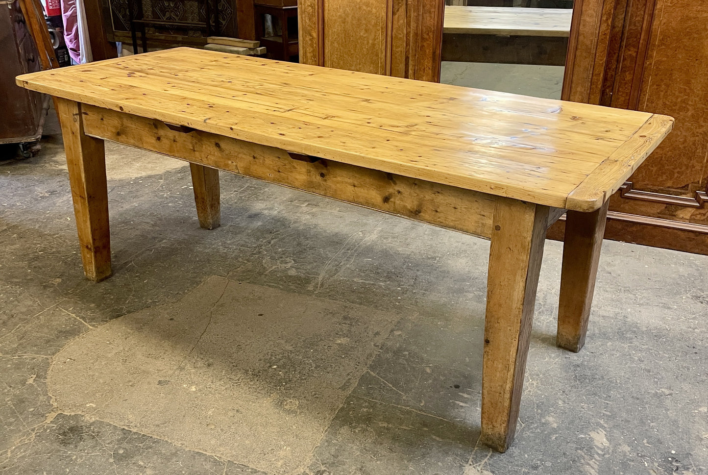 Wooden table on a concrete floor with wooden cabinets in the background