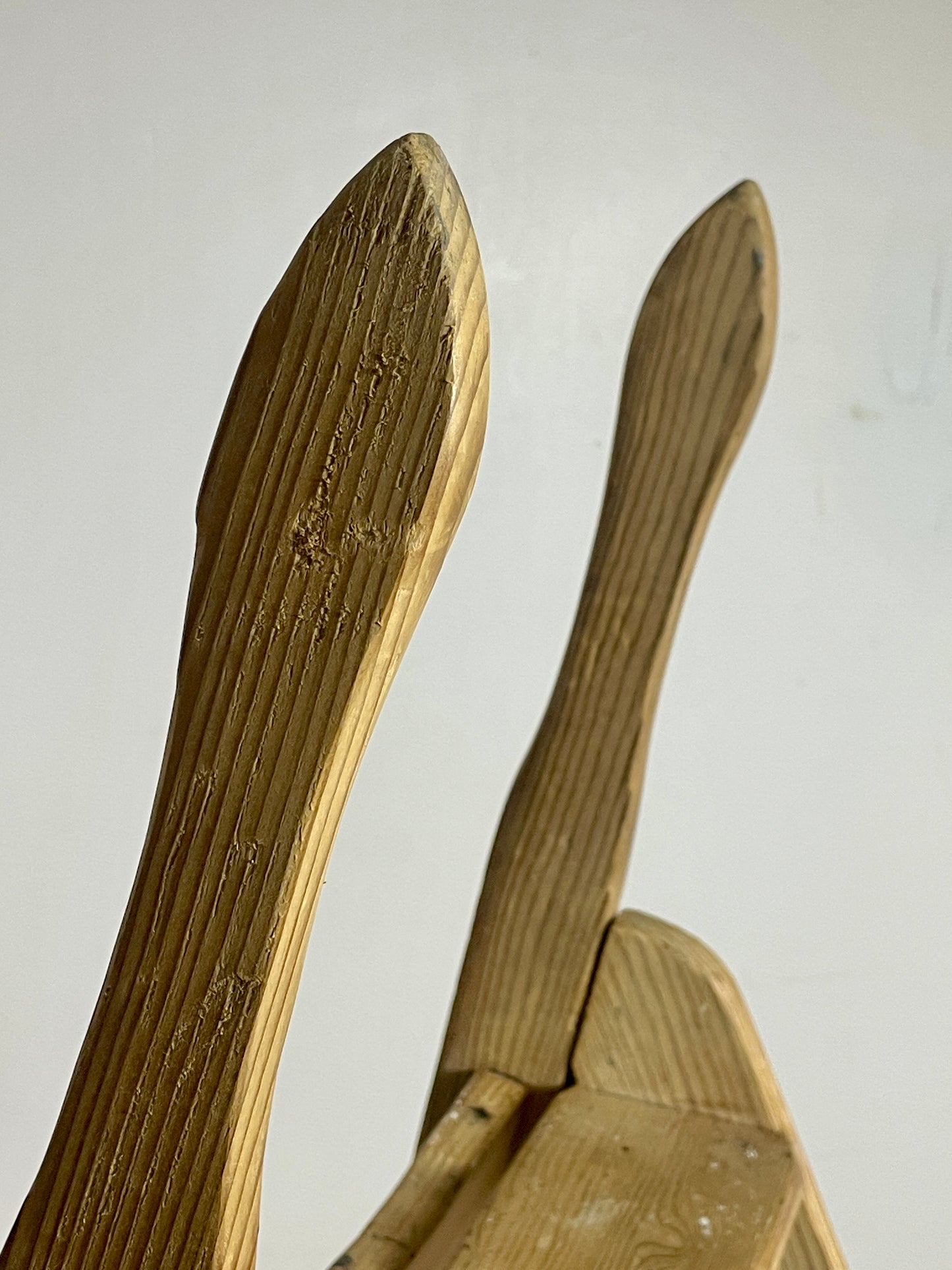 Three wooden spoons with a textured surface on a light gray background