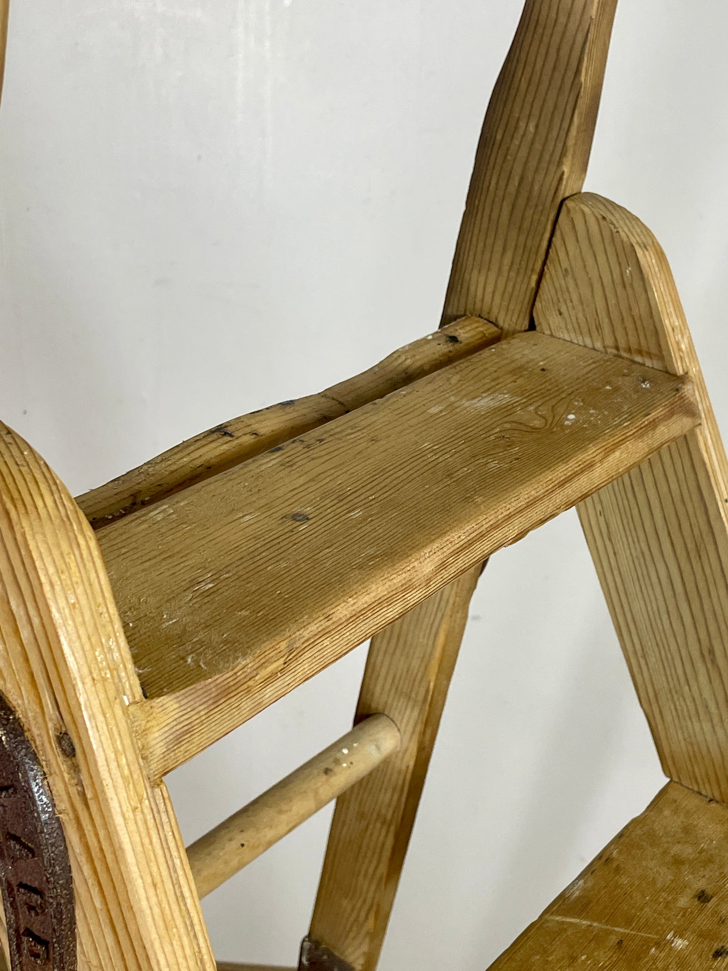Wooden step ladder against a white wall