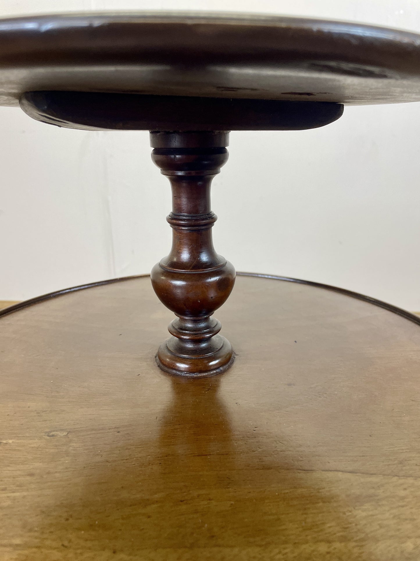 Wooden pedestal table with a round top on a white background