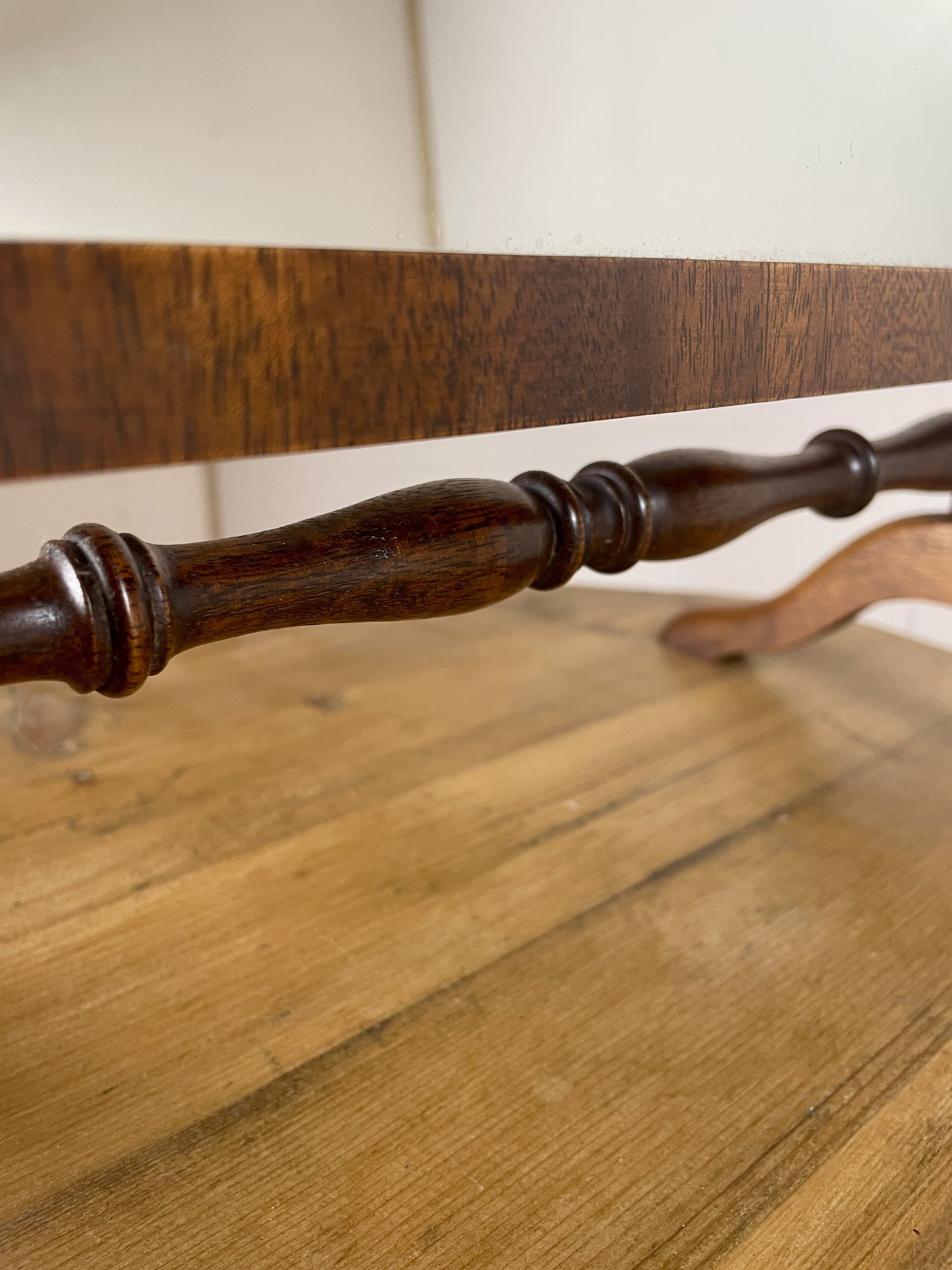 Close-up of a wooden chair with a spindle backrest on a wooden floor.