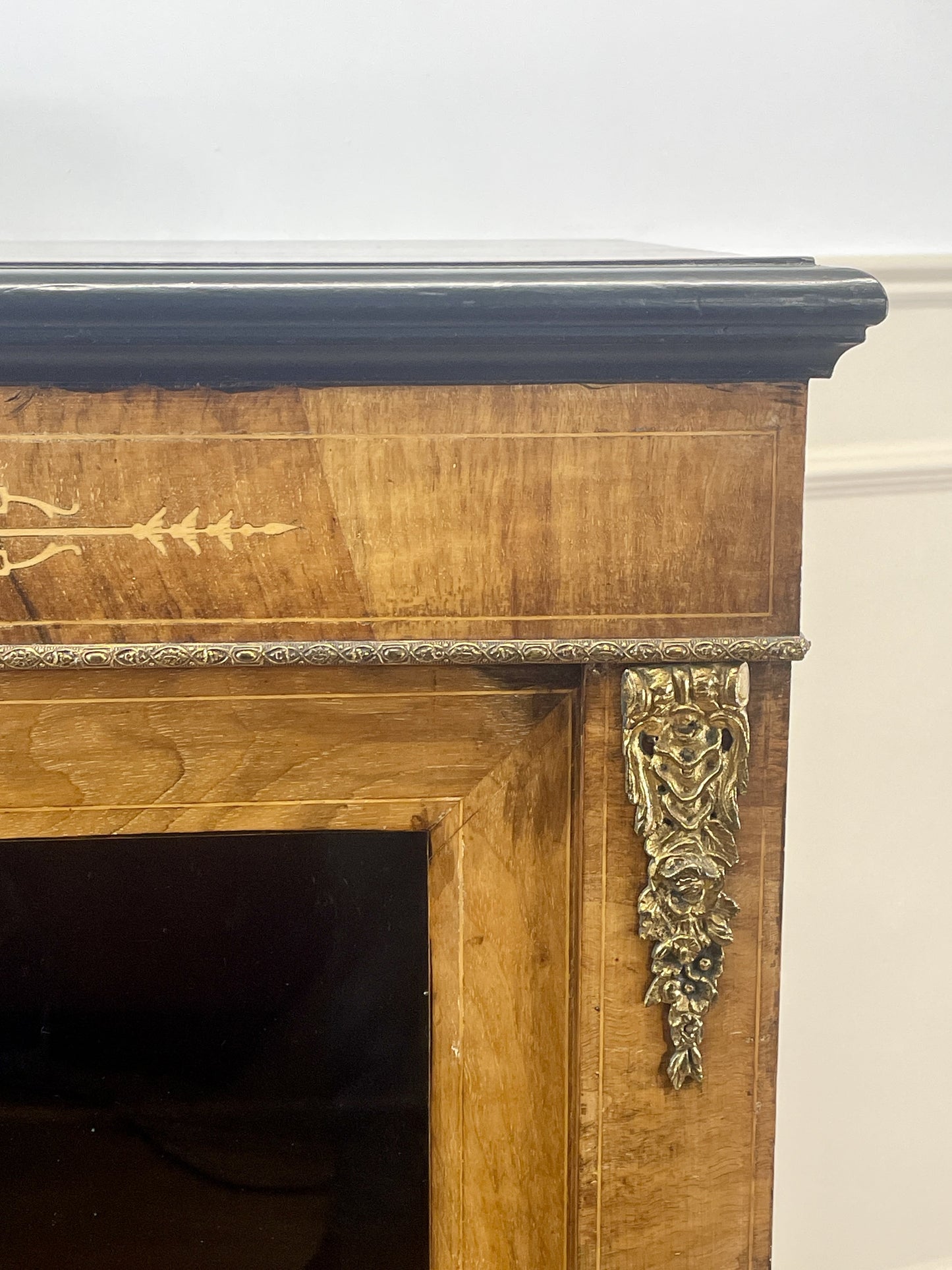 Wooden fireplace mantel with decorative carvings on a white wall