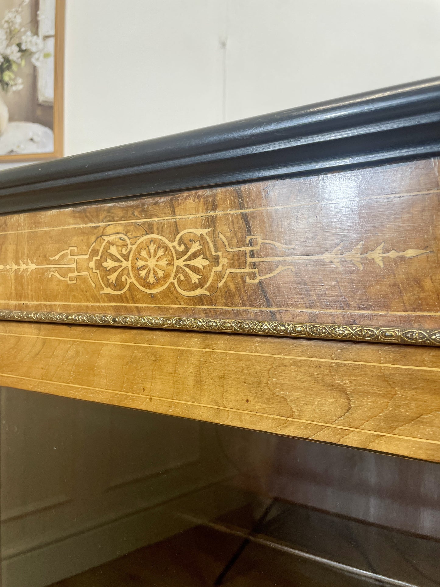 Wooden dresser with decorative carvings on a white wall background