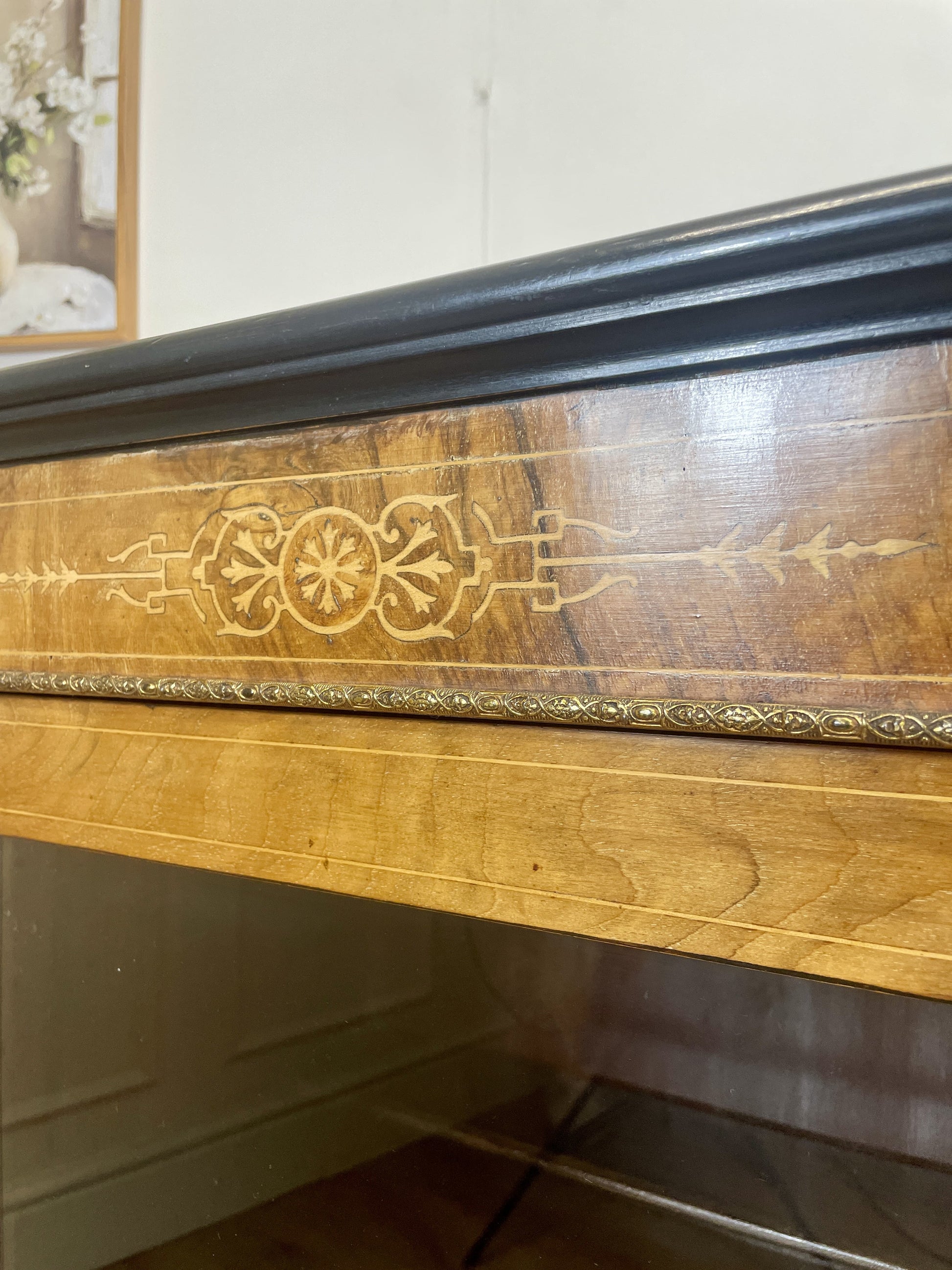 Wooden dresser with decorative carvings on a white wall background