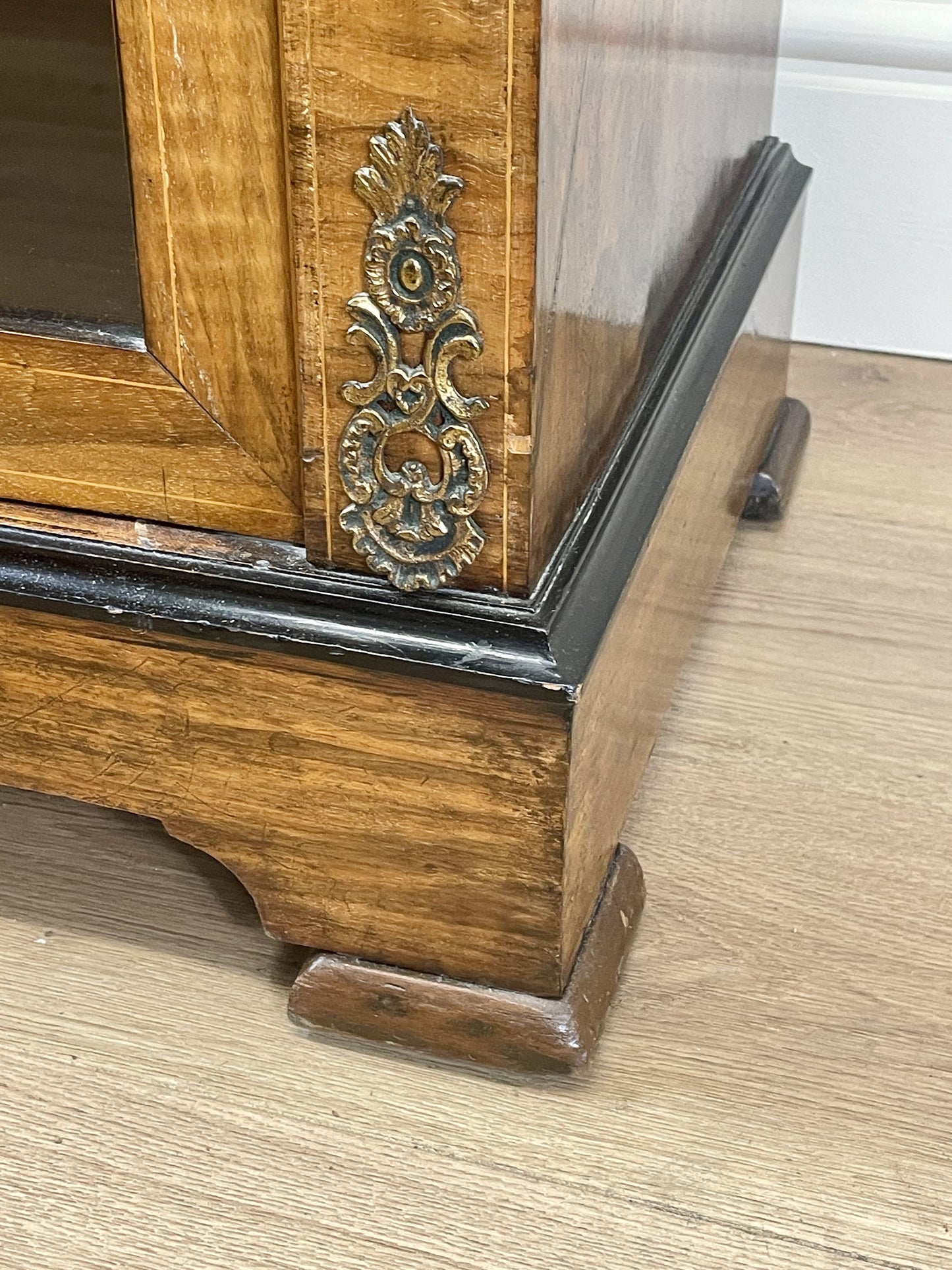 Wooden cabinet with decorative metal handle on a wooden floor