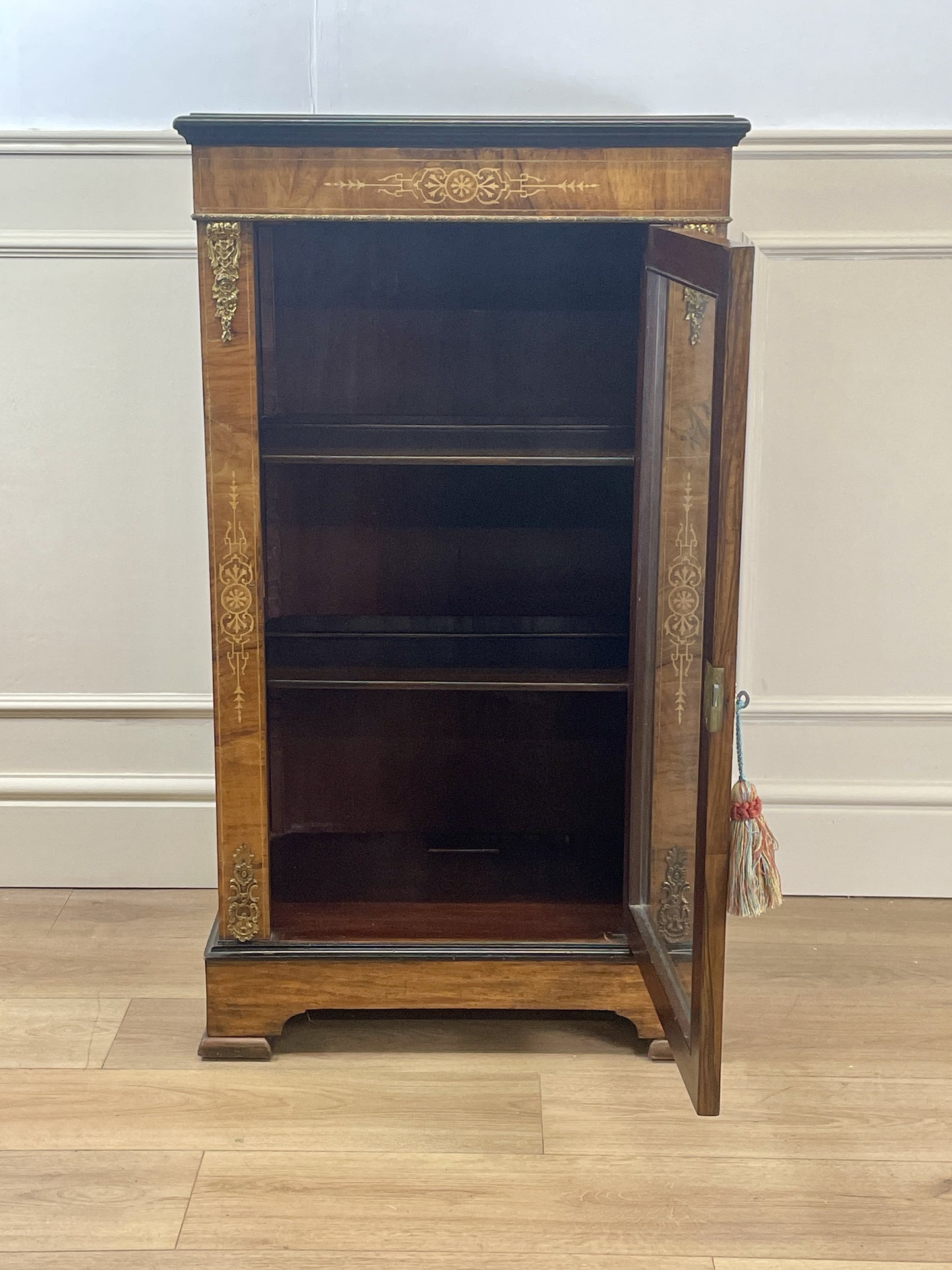 Wooden cabinet with decorative elements on a white wall background