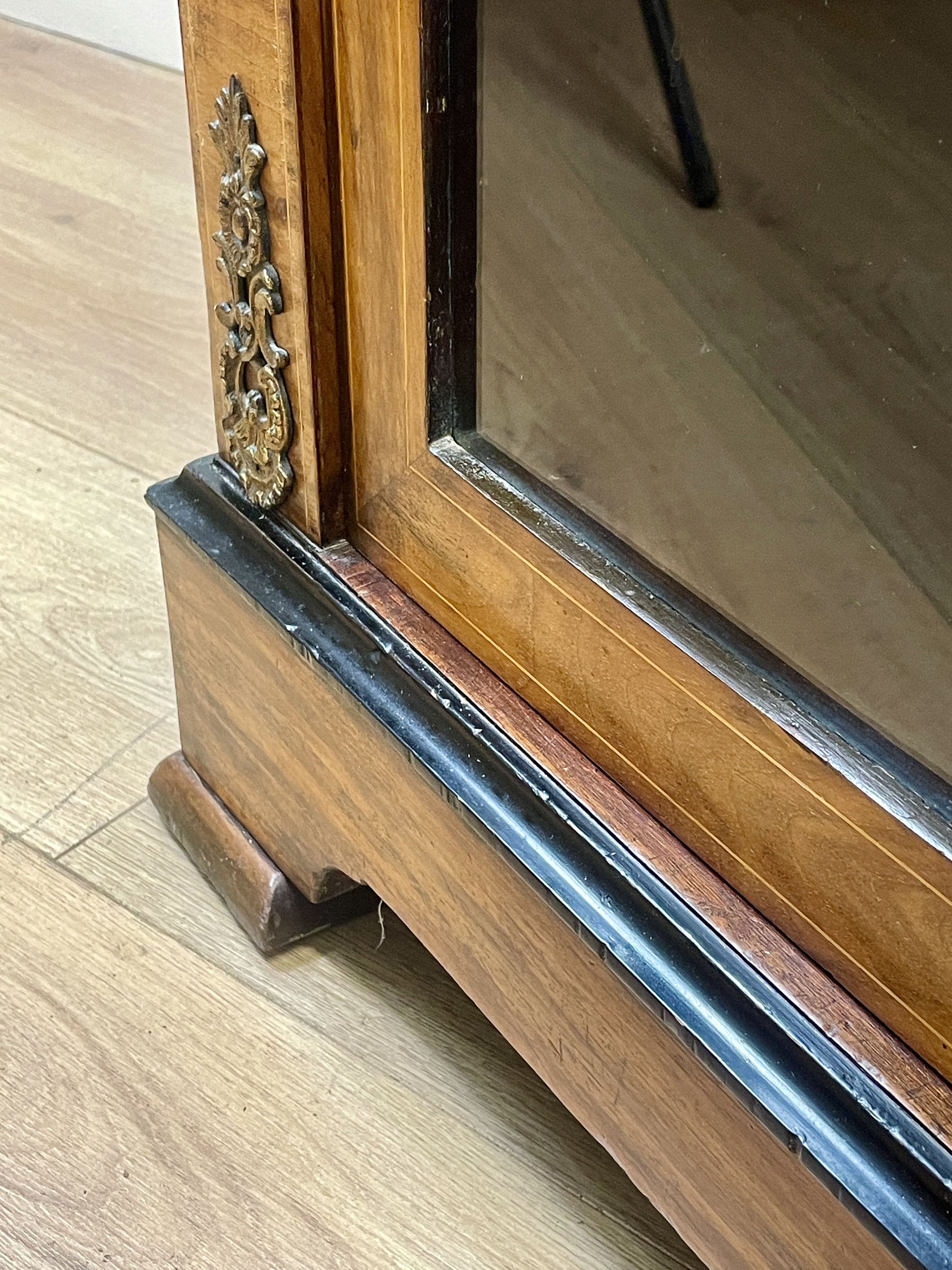 Wooden mirror with decorative frame on a wooden floor