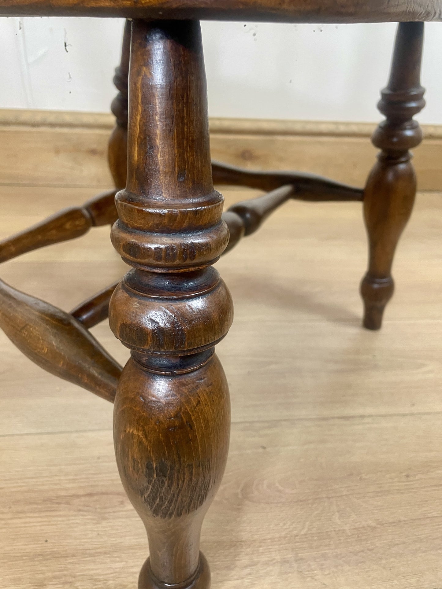 Wooden table leg on a wooden floor with a neutral background