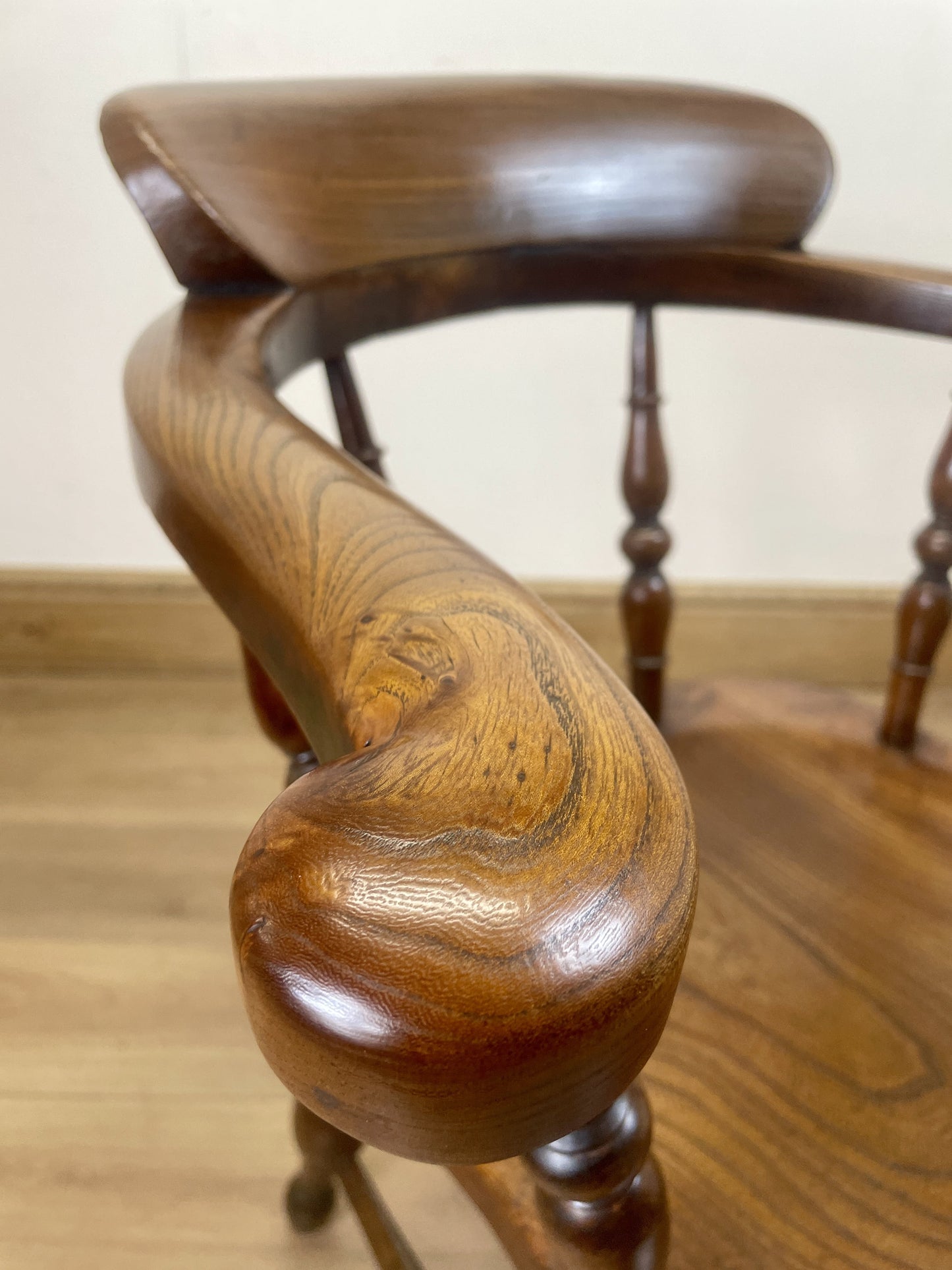 Close-up of a wooden chair with intricate design on a wooden floor.