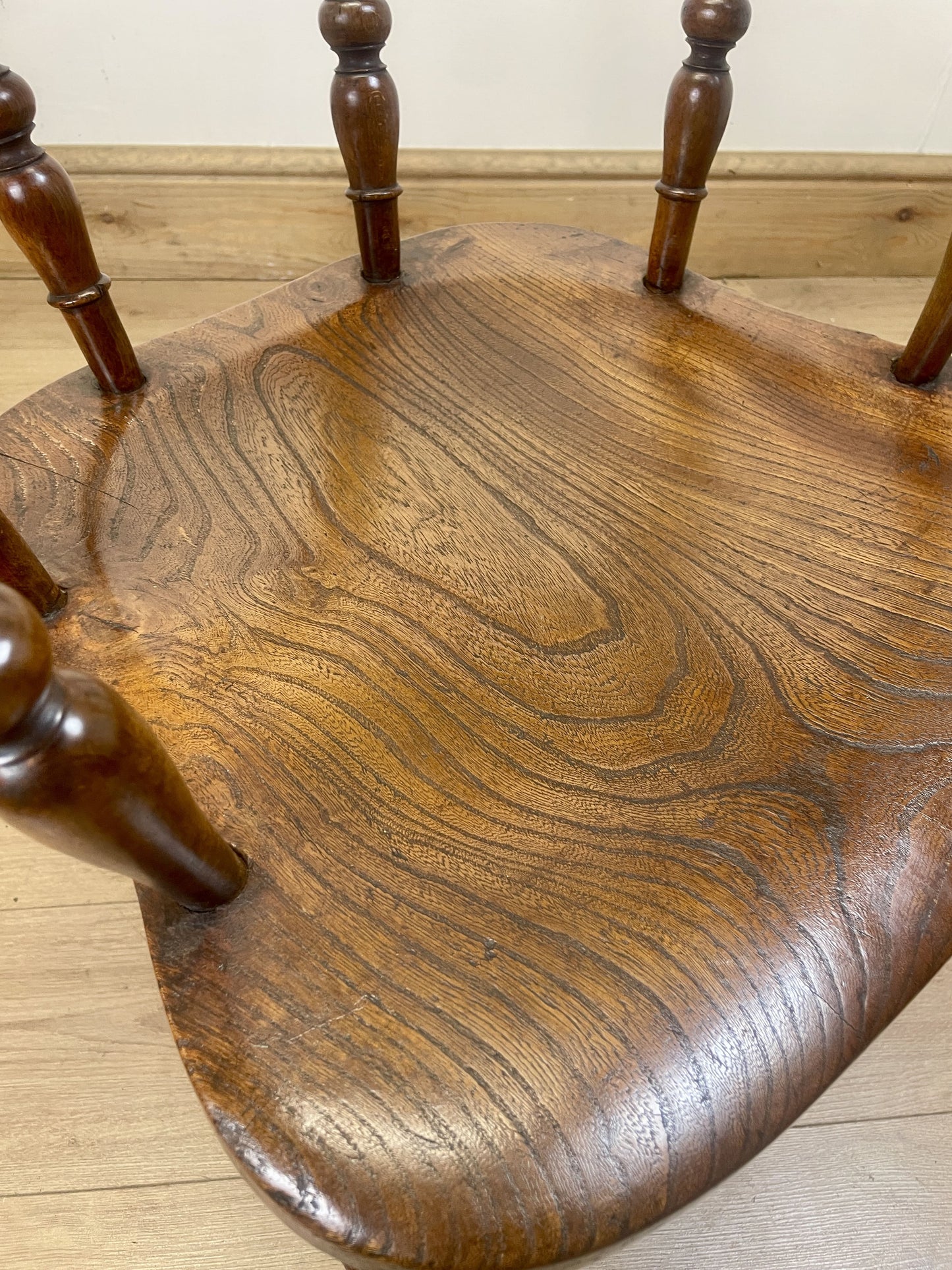 Close-up of a wooden chair seat with visible grain and texture.