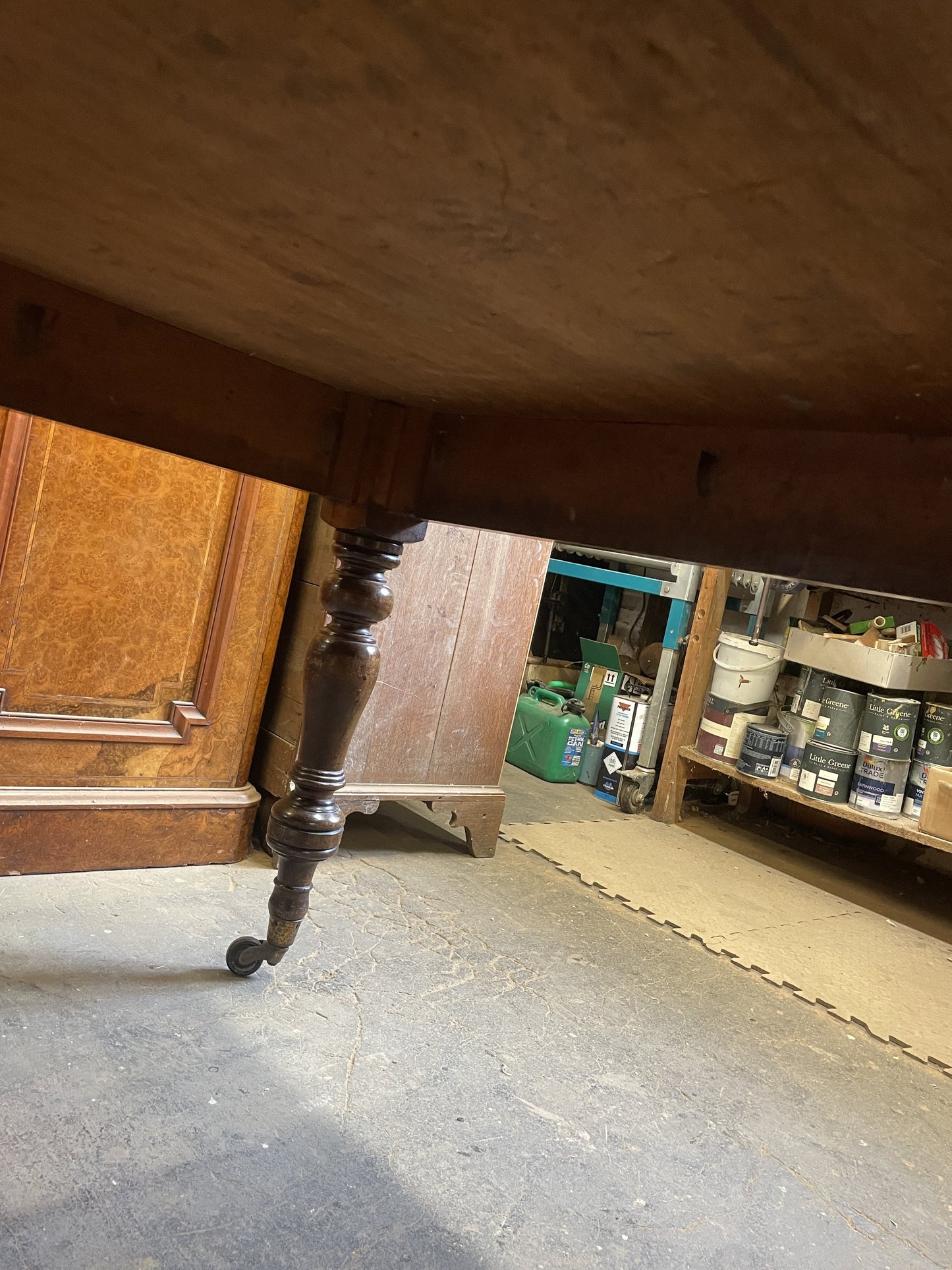 Close-up of a wooden leg on a table with a storage area in the background