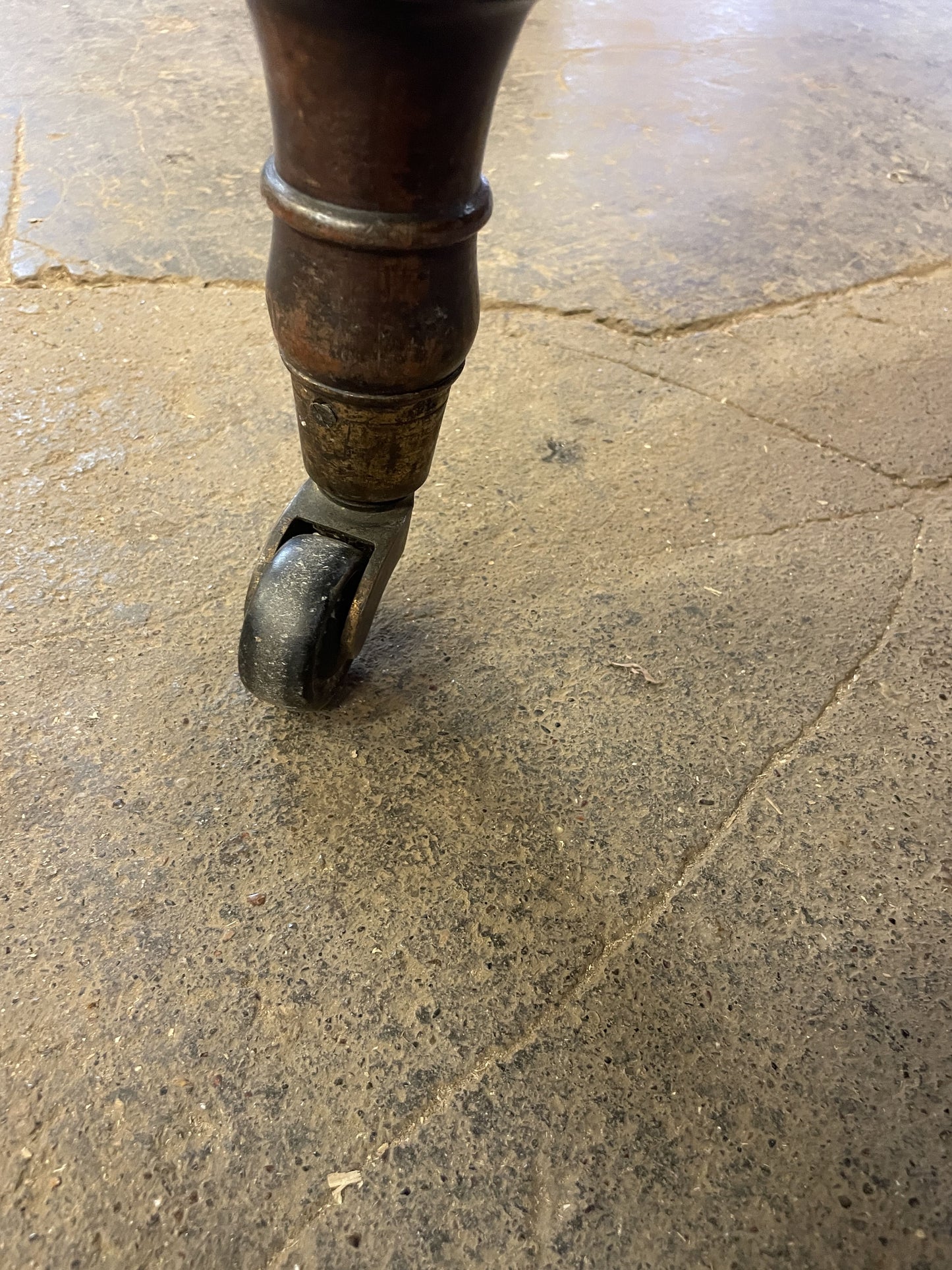 Close-up of a metal wheel on a textured stone floor