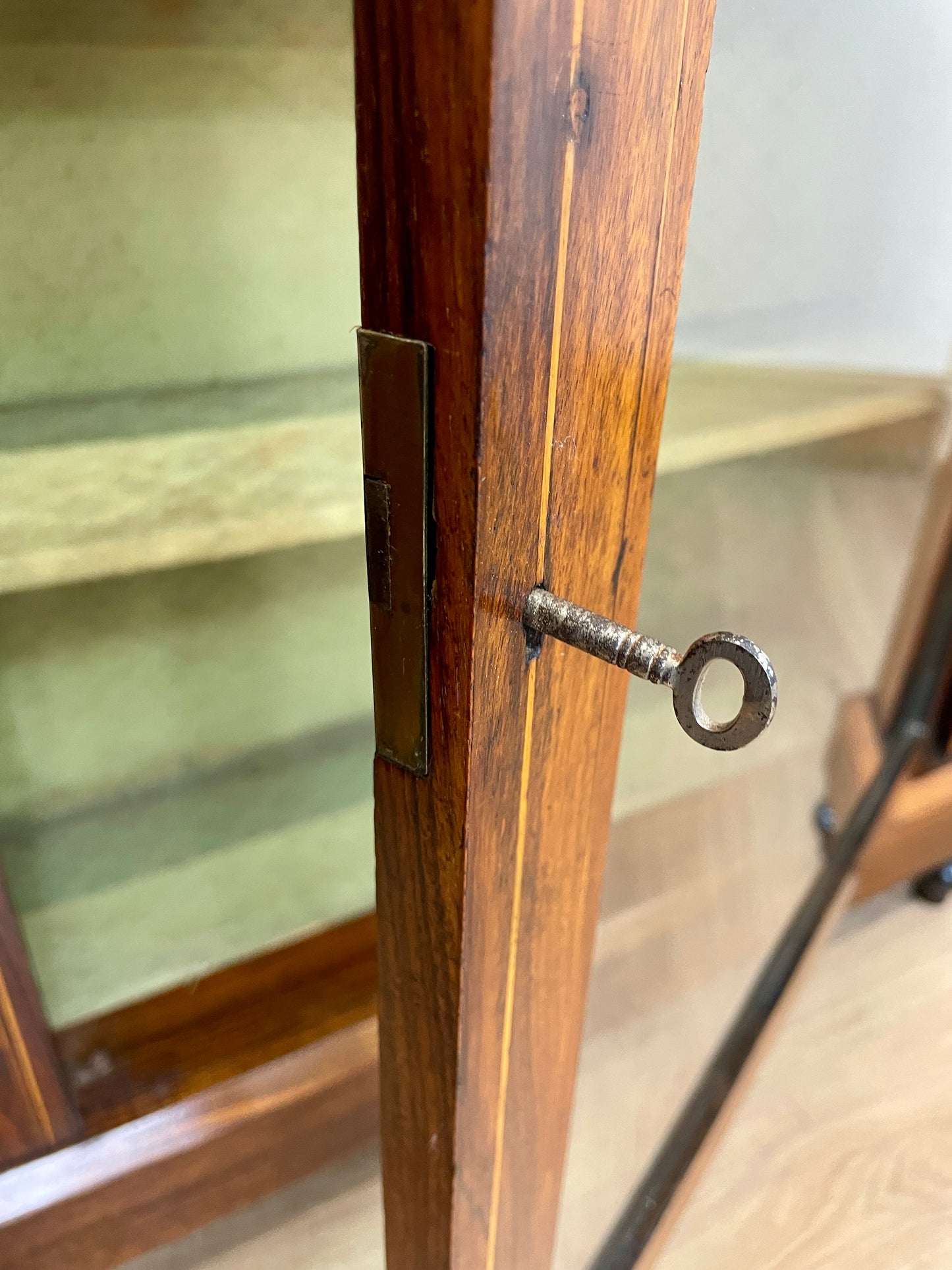 Close-up of a wooden cabinet with a keyhole and glass door.