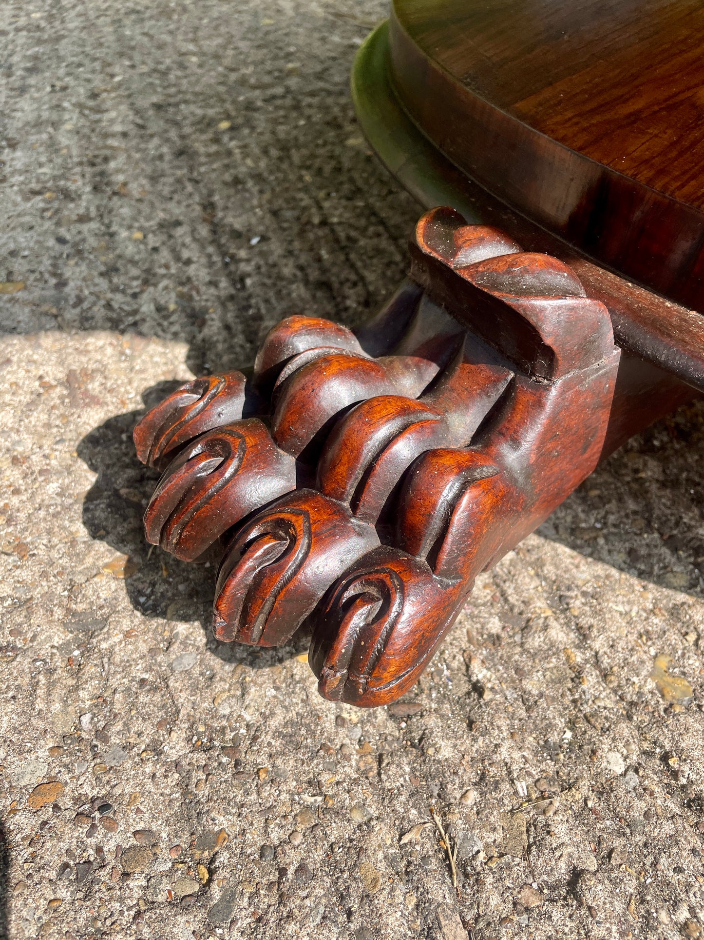 Carved wooden foot on a stone surface