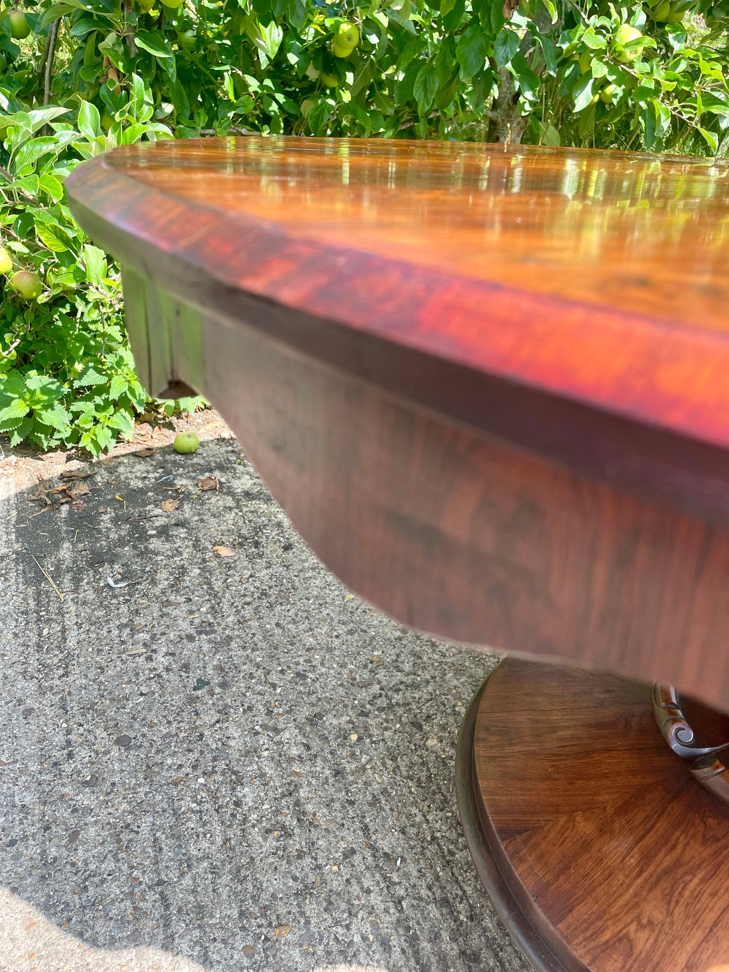 Rustic metal bowl on a textured surface with greenery in the background