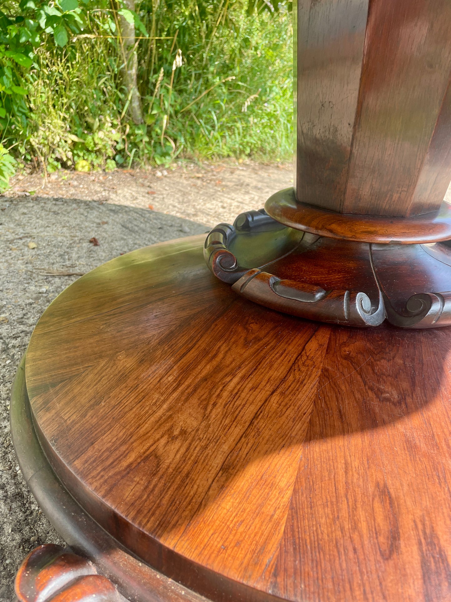 Wooden table with metal base on a natural outdoor background