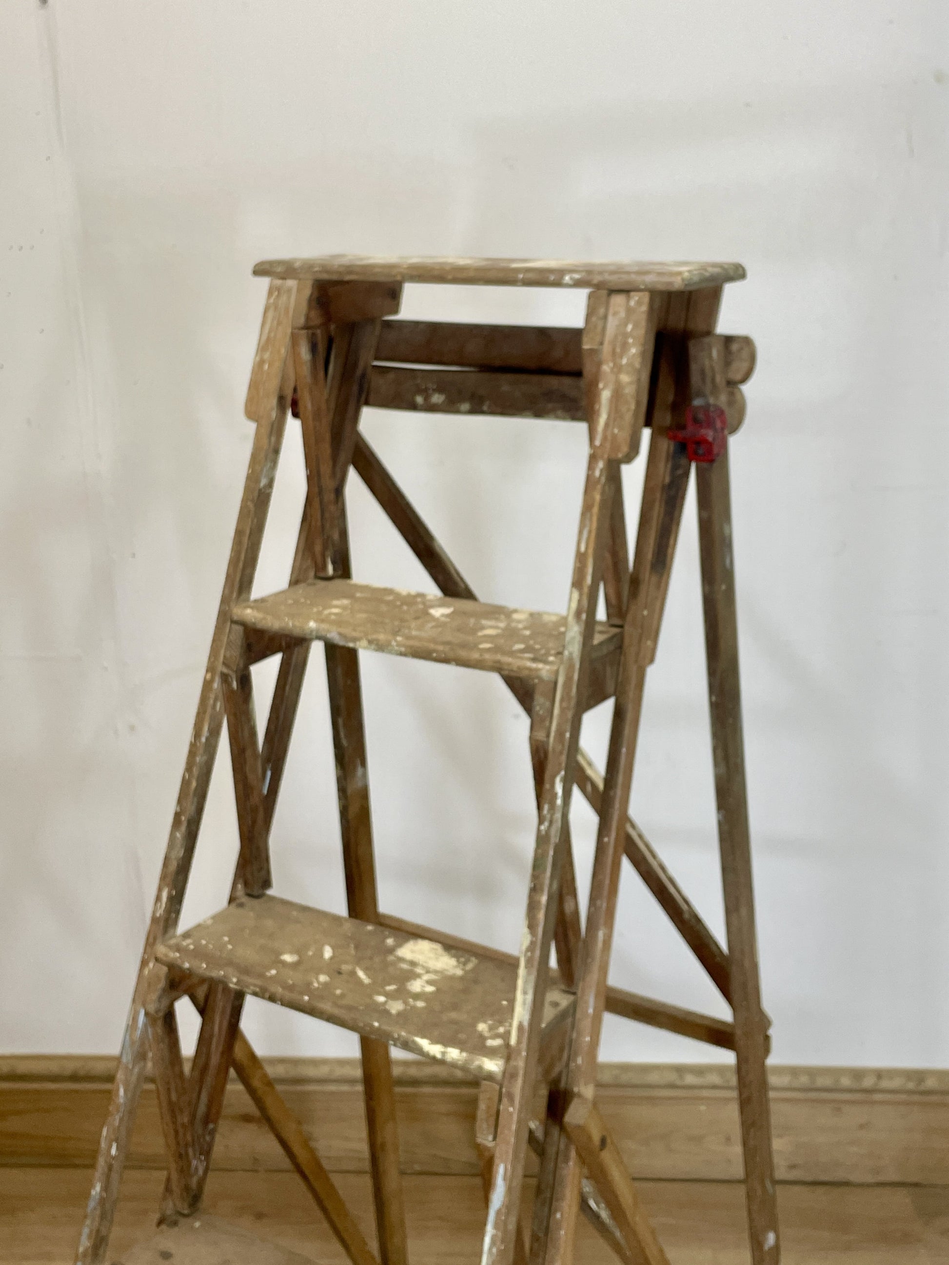 Wooden step ladder against a white wall