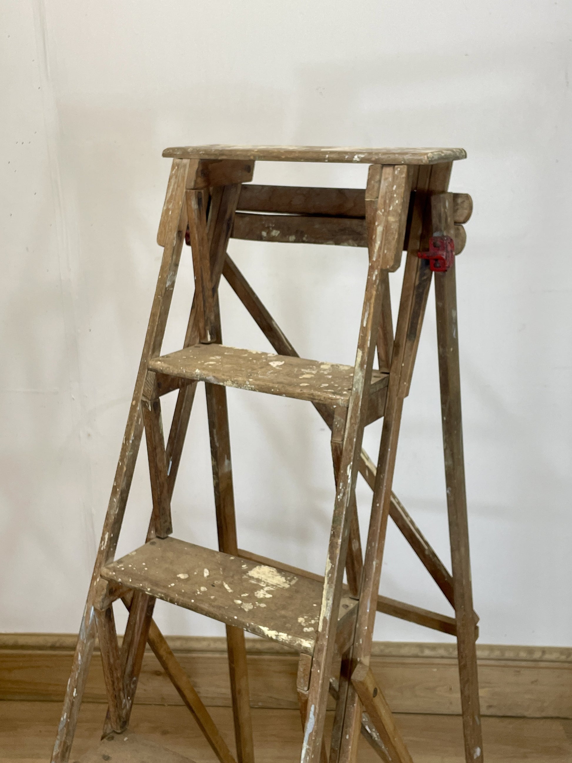 Wooden step ladder against a white wall