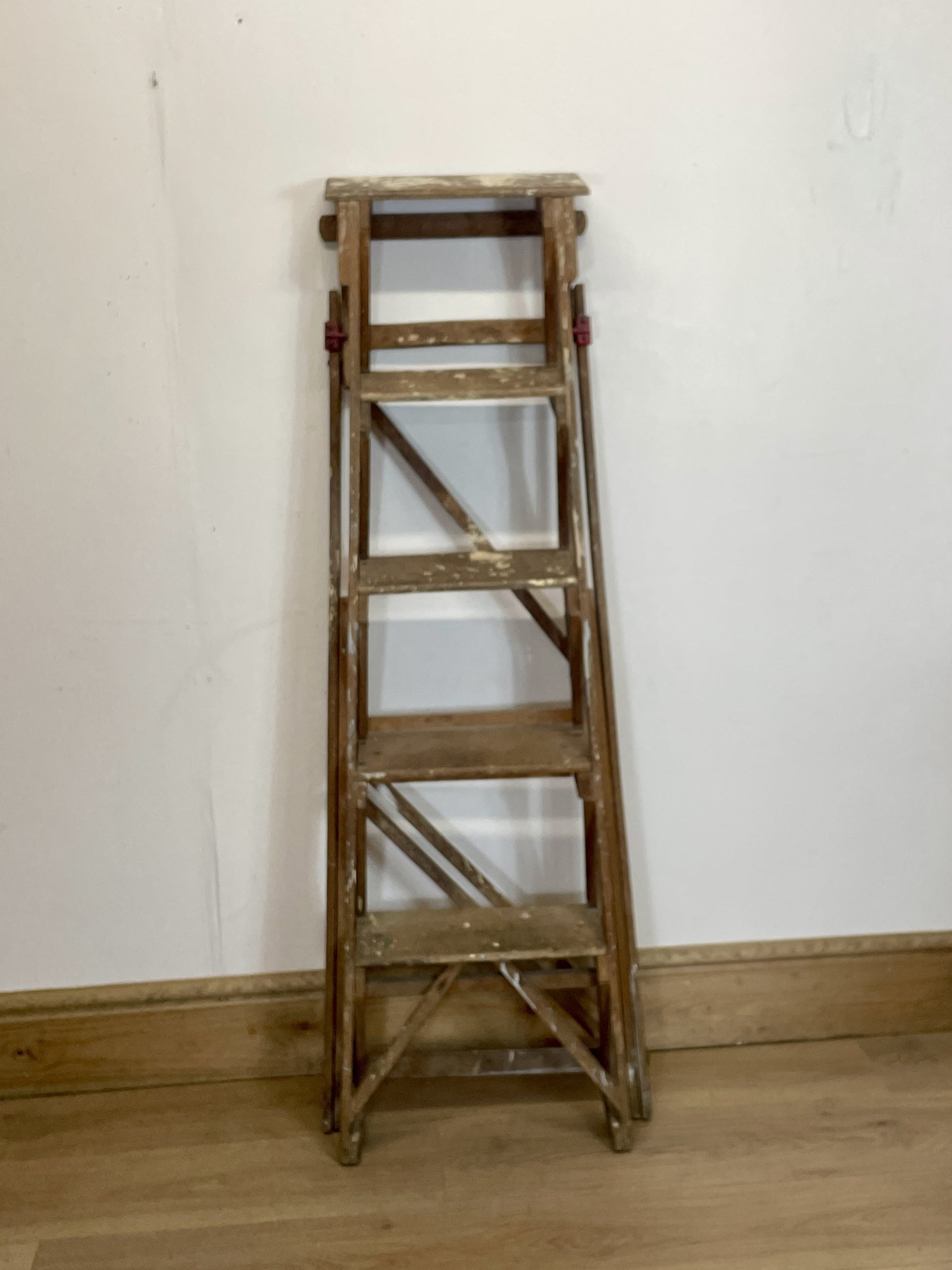 Wooden step ladder against a white wall