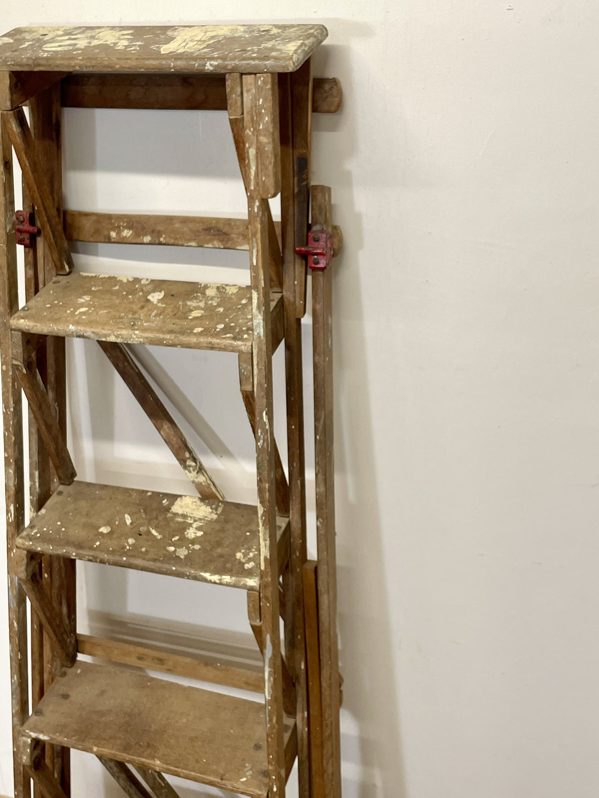 Wooden step ladder against a white wall