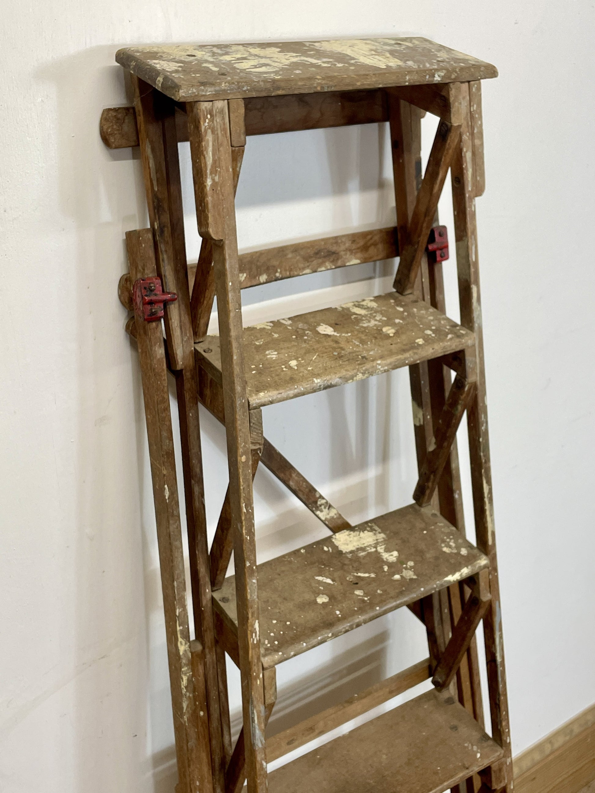 Wooden step ladder against a white wall