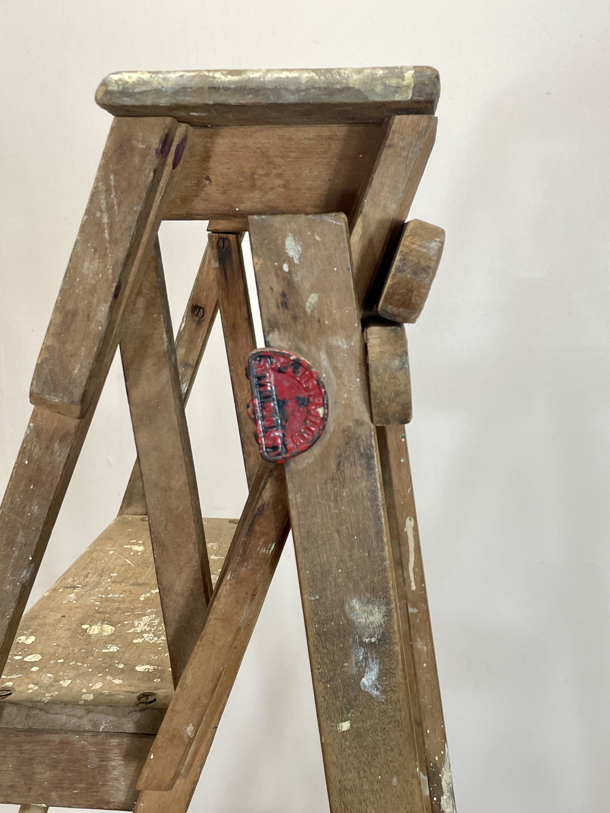 Wooden step ladder with a red and blue patch on a white background