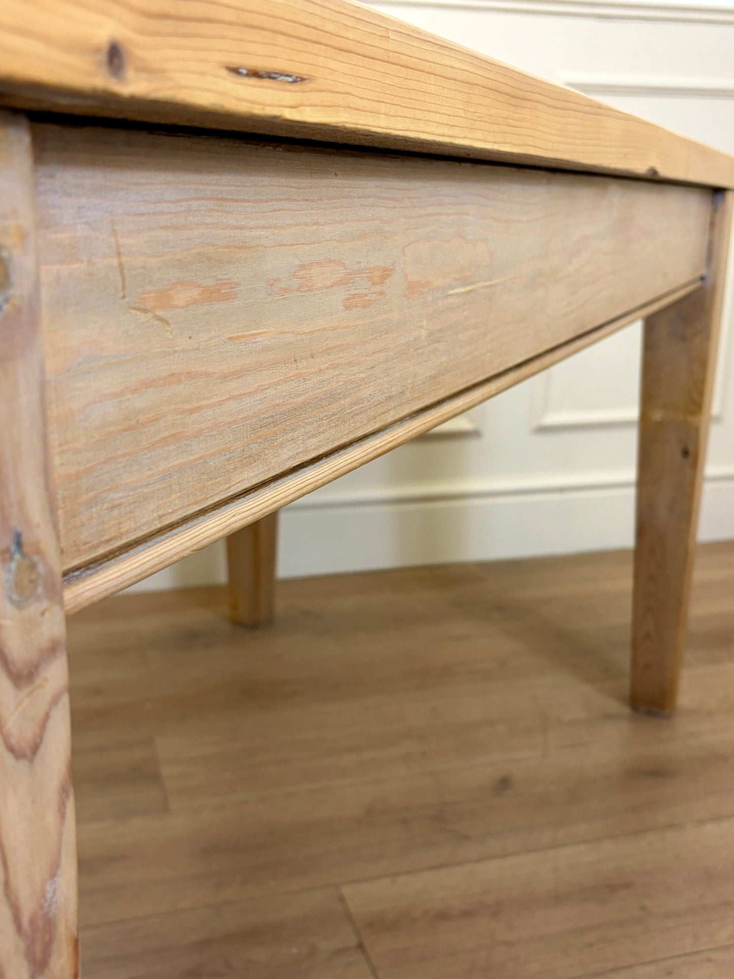 Wooden desk with a light finish on a wooden floor.
