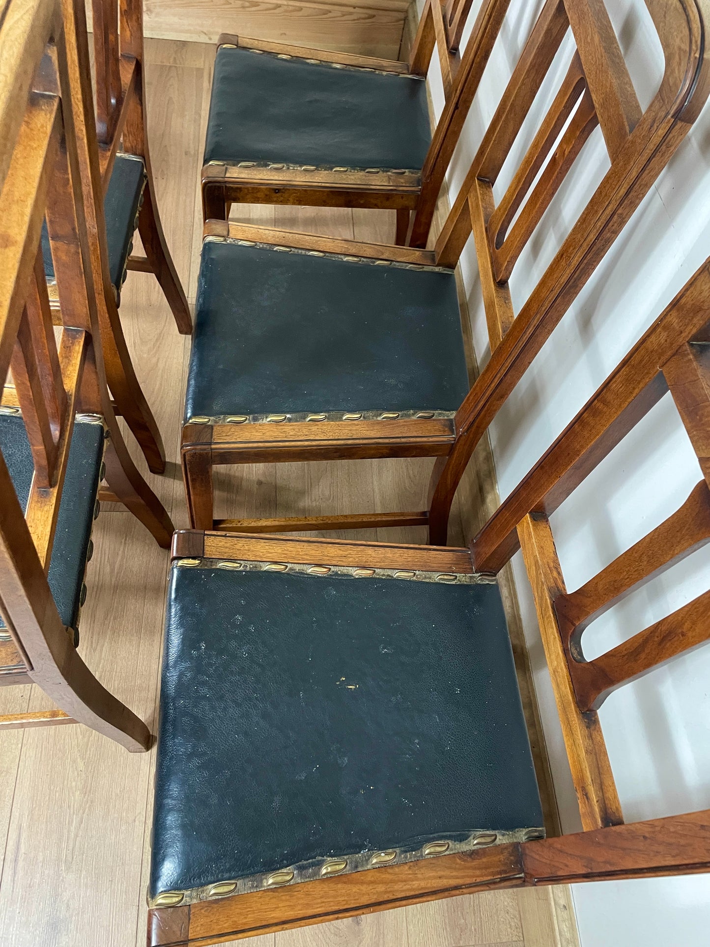 Wooden chairs with black seats on a wooden floor