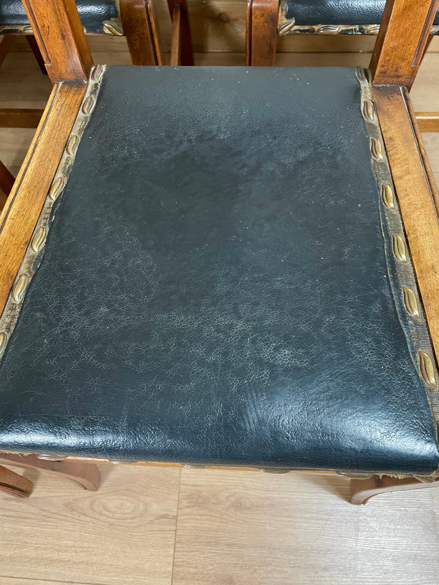 Black leather chair seat with wooden frame on a wooden floor