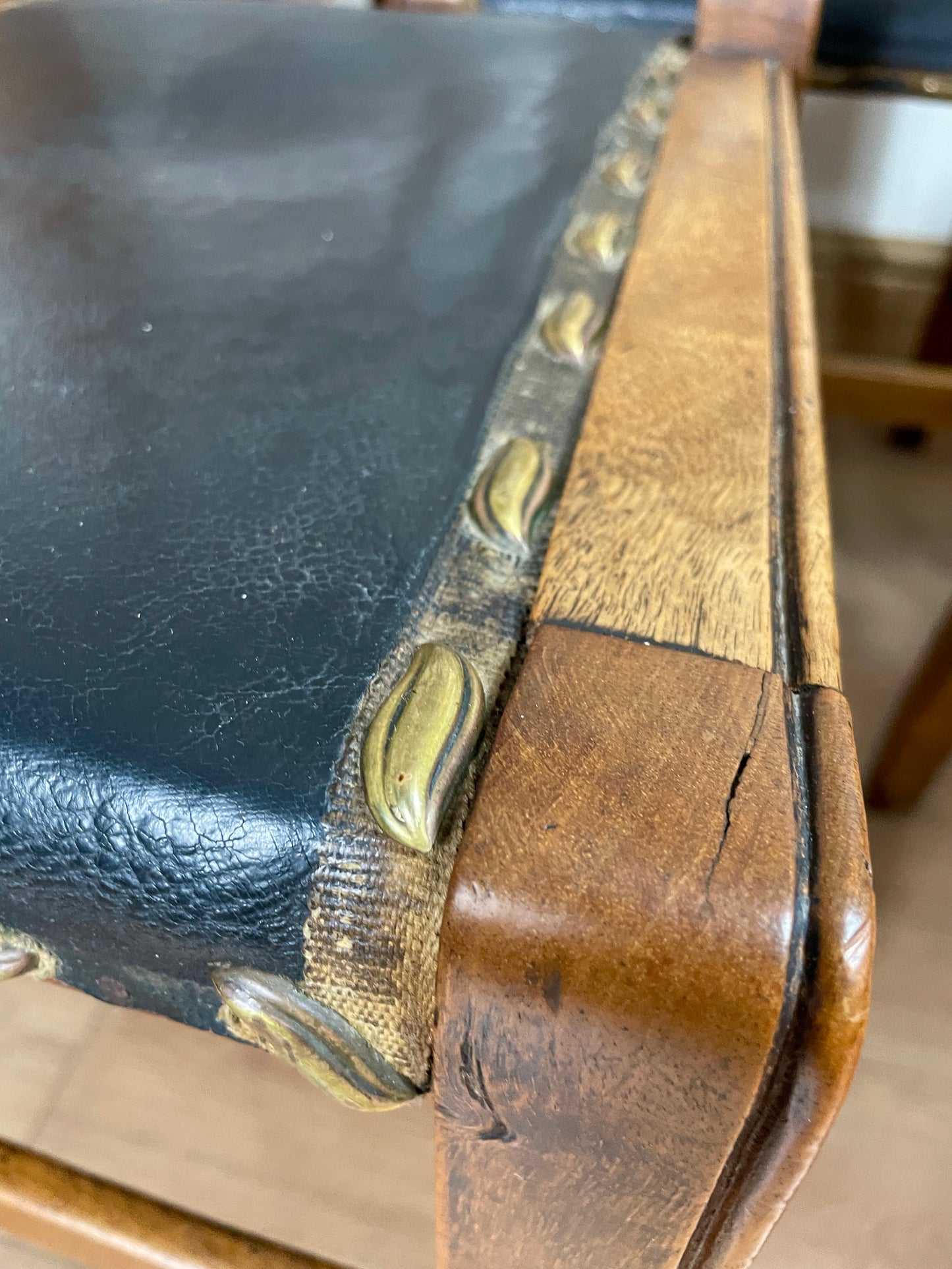 Close-up of a leather bag with gold hardware on a wooden surface