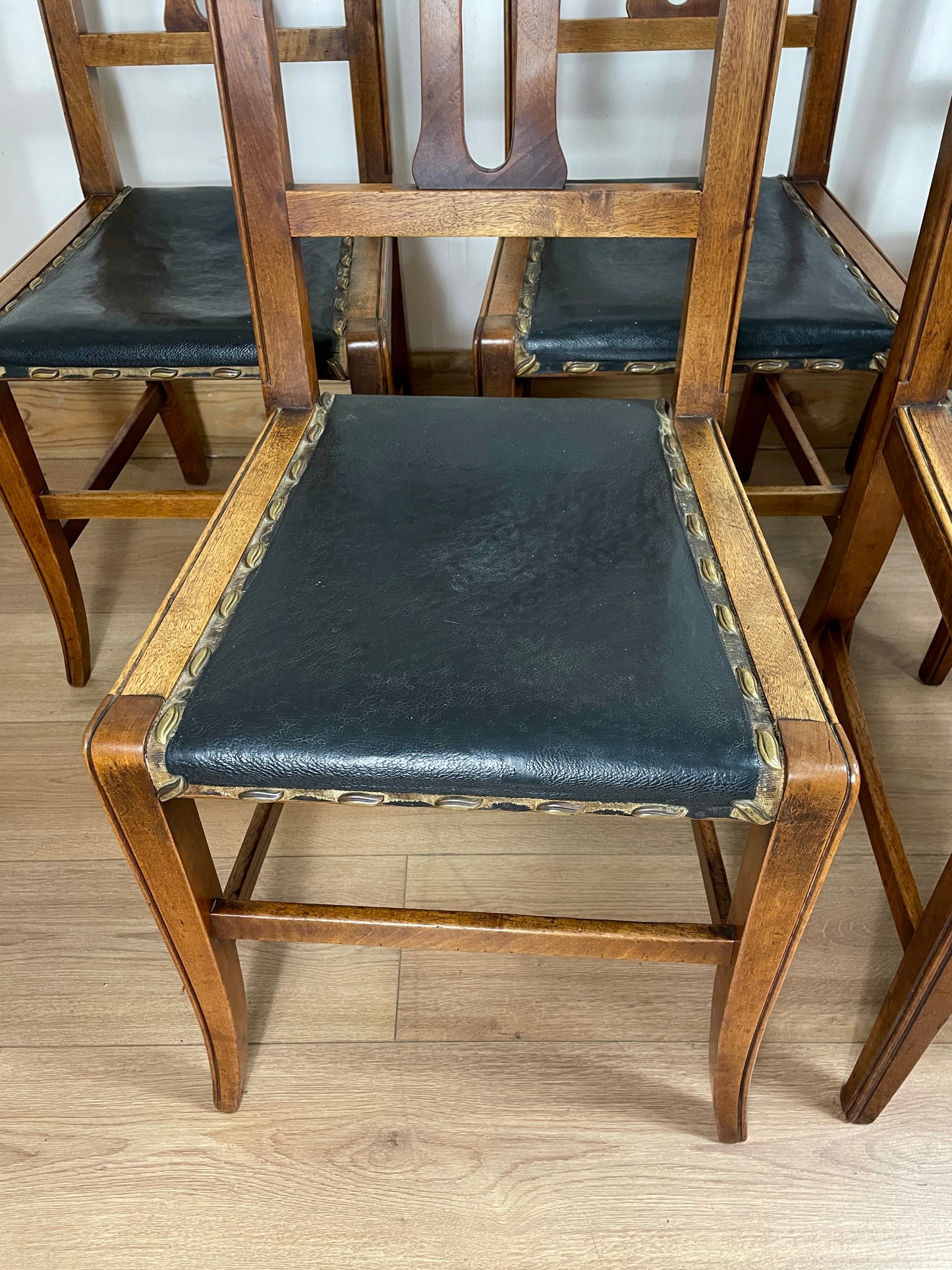 Wooden chair with black leather seat on a wooden floor