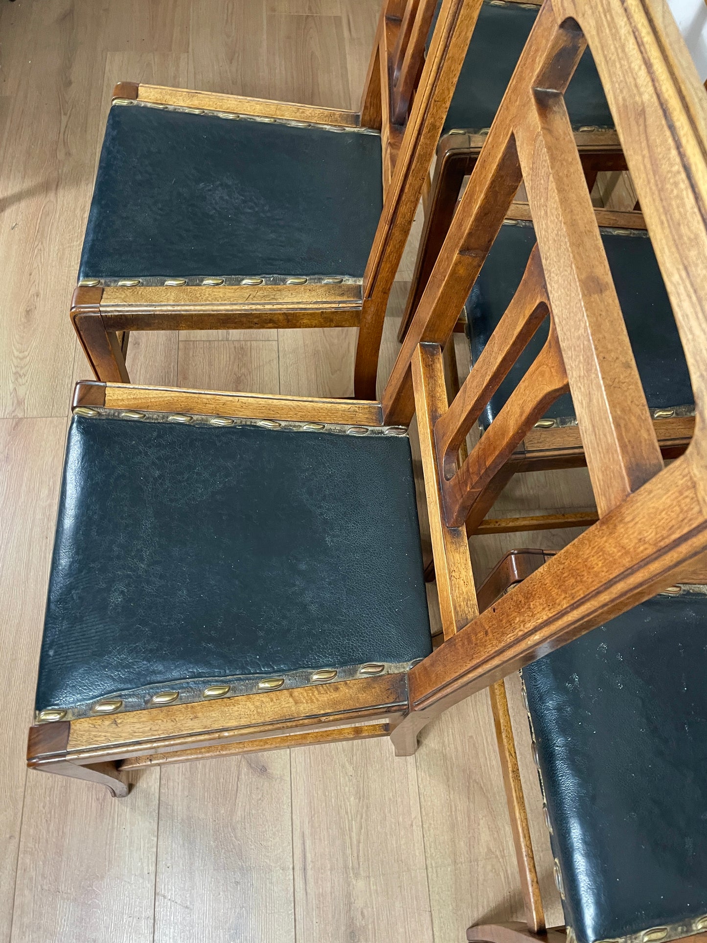 Wooden chairs with dark leather seats on a wooden floor