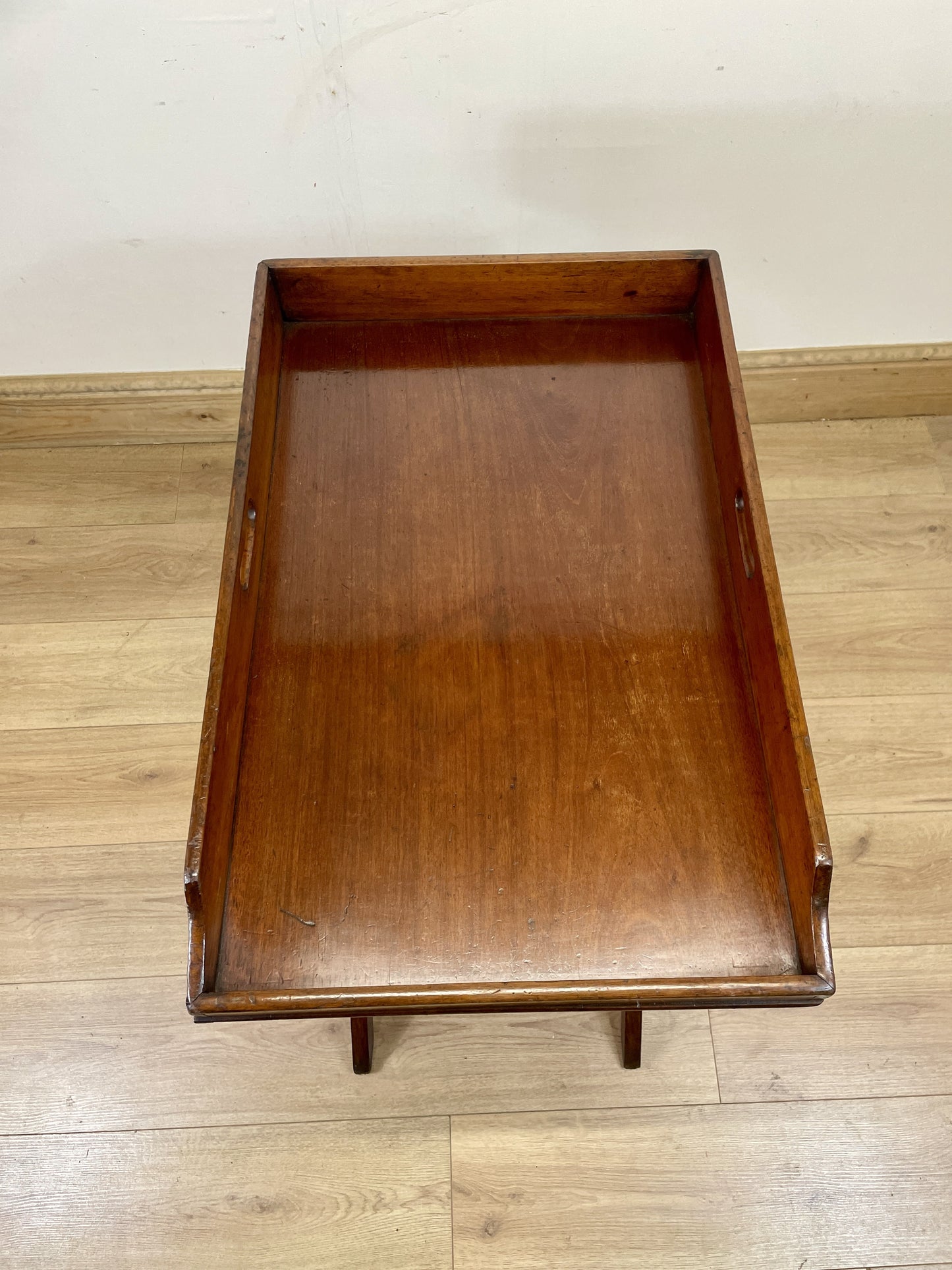Wooden tray on a wooden floor with a plain background