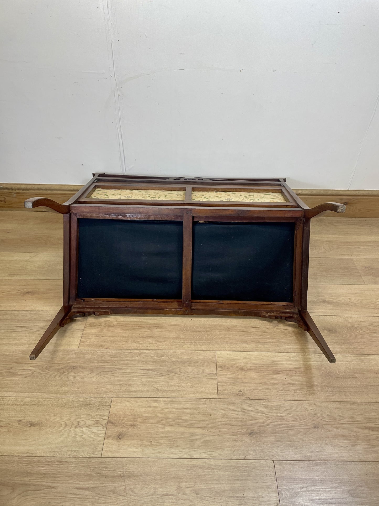 Wooden display case with glass top on a wooden floor