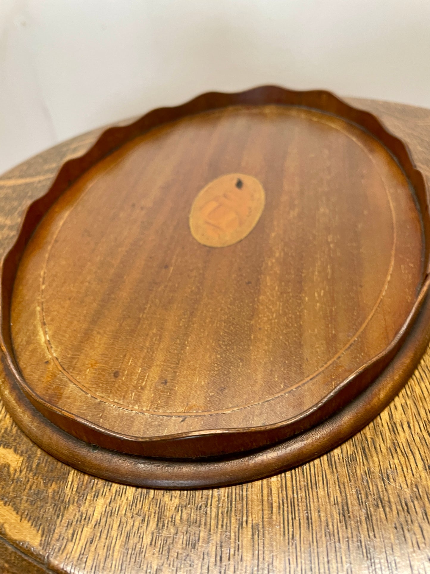 Wooden tray with a central circular emblem on a wooden surface