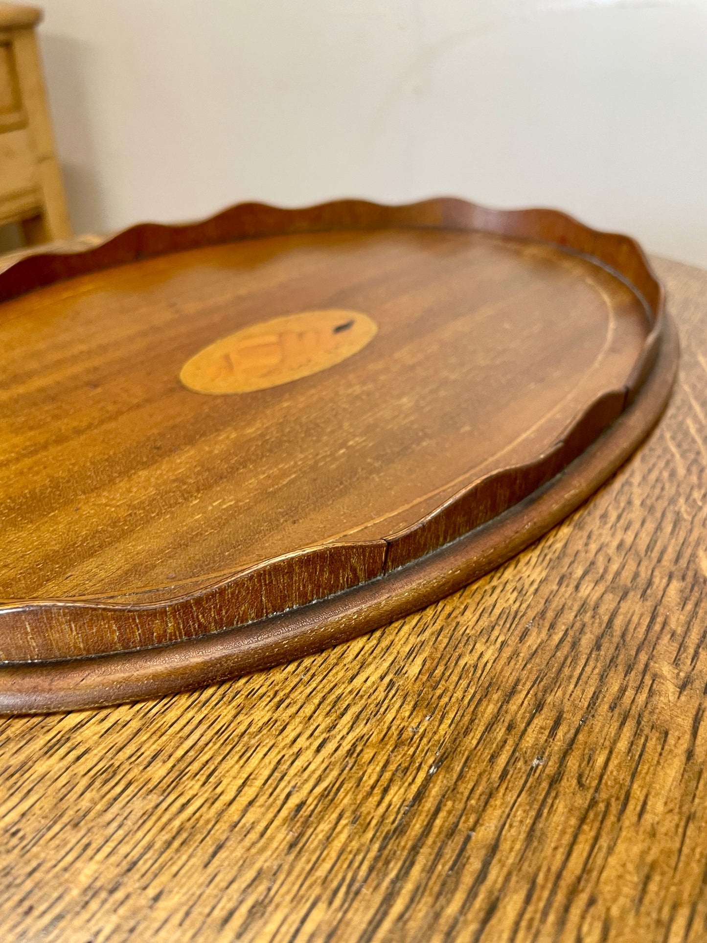 Wooden tray with inlaid design on a wooden surface