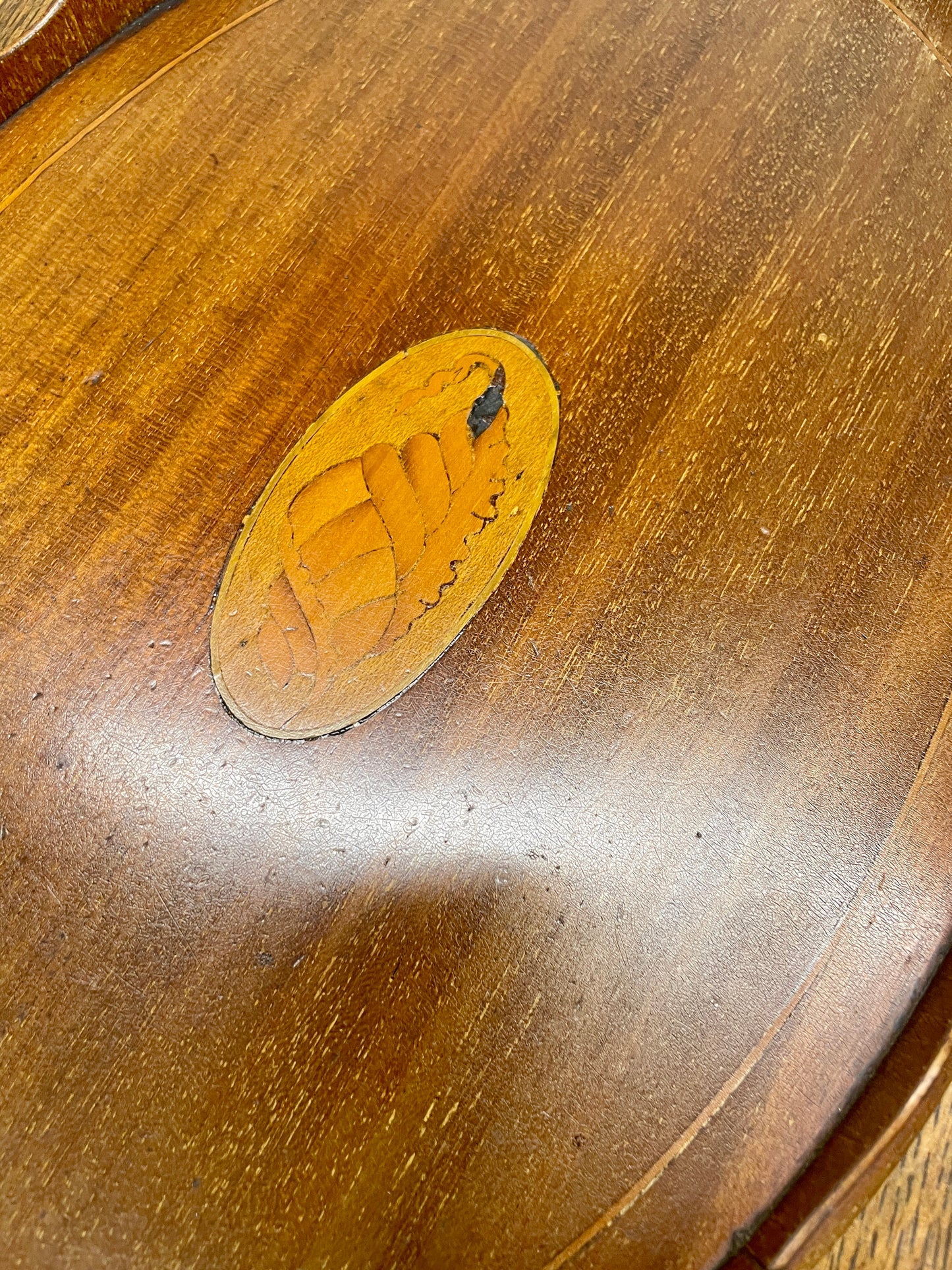 Wooden surface with a circular wooden inlay featuring a paw print design.