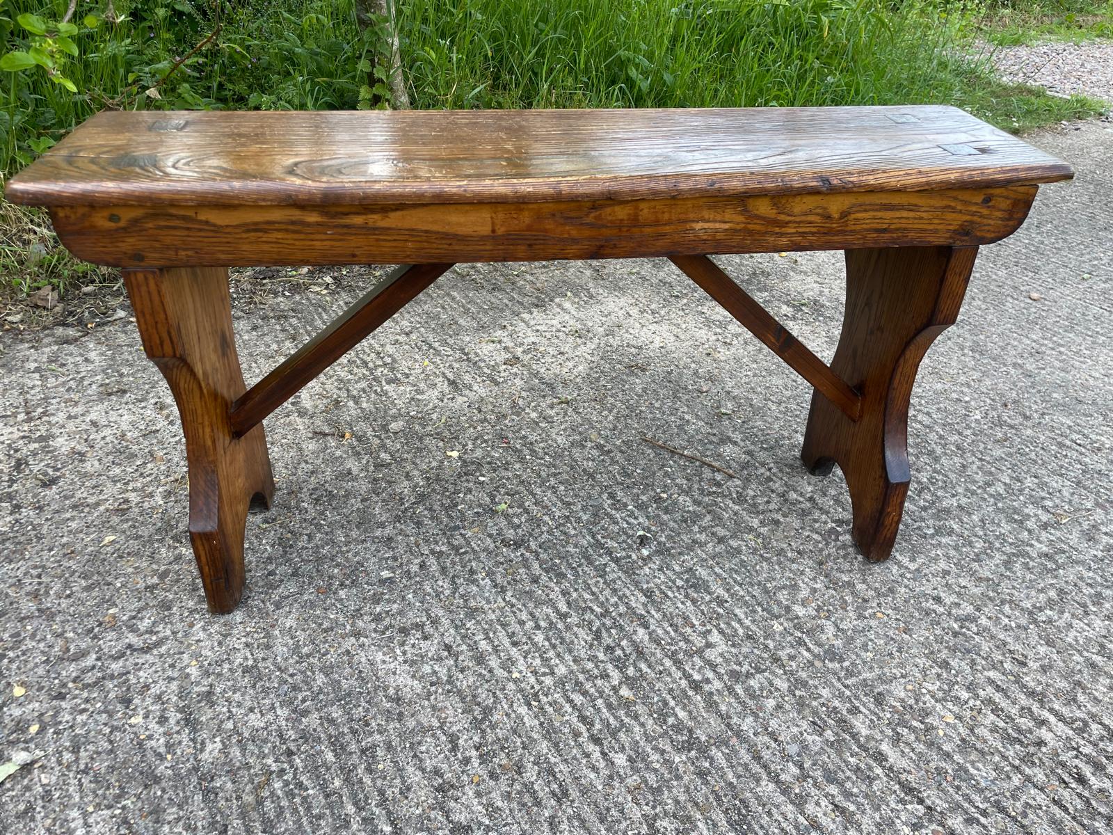 Wooden bench on a concrete surface with grass in the background