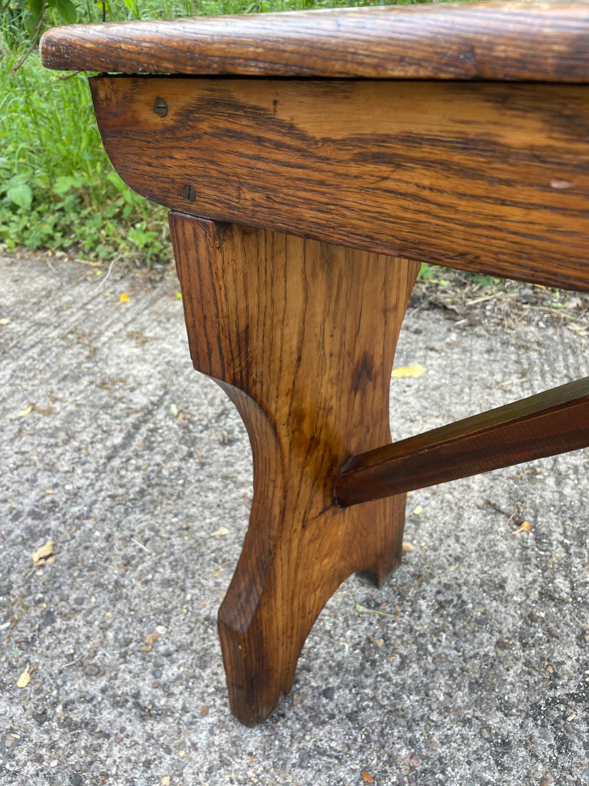 Close-up of a wooden table leg on a concrete surface with grass in the background